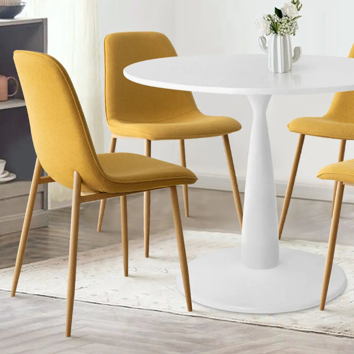 Haven & Oslo dining set with mustard chairs, wooden flooring, and white walls in dining room.