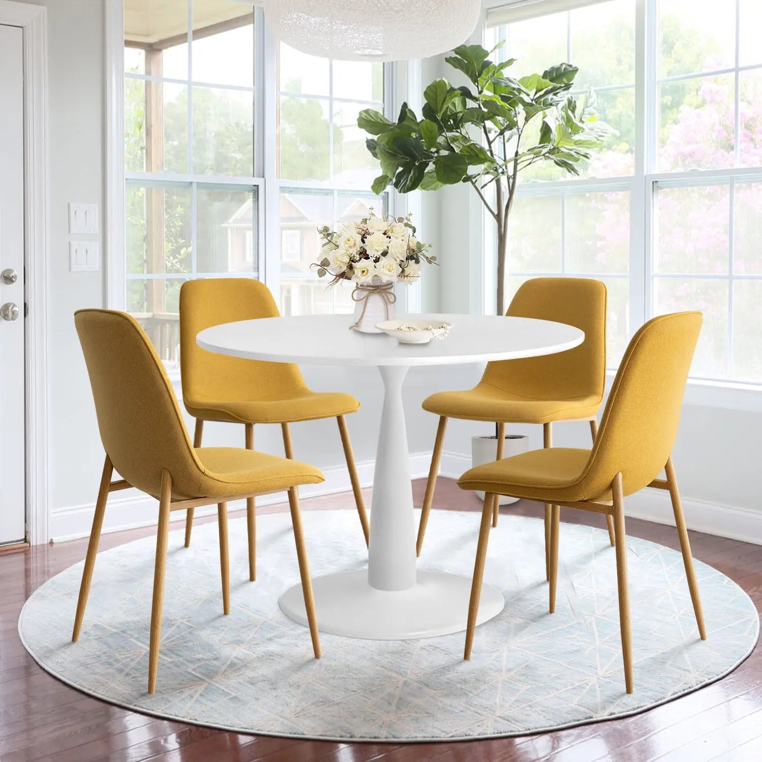 Haven & Oslo White Round Dining Table Set with mustard chairs, in sunlit room with wooden flooring.