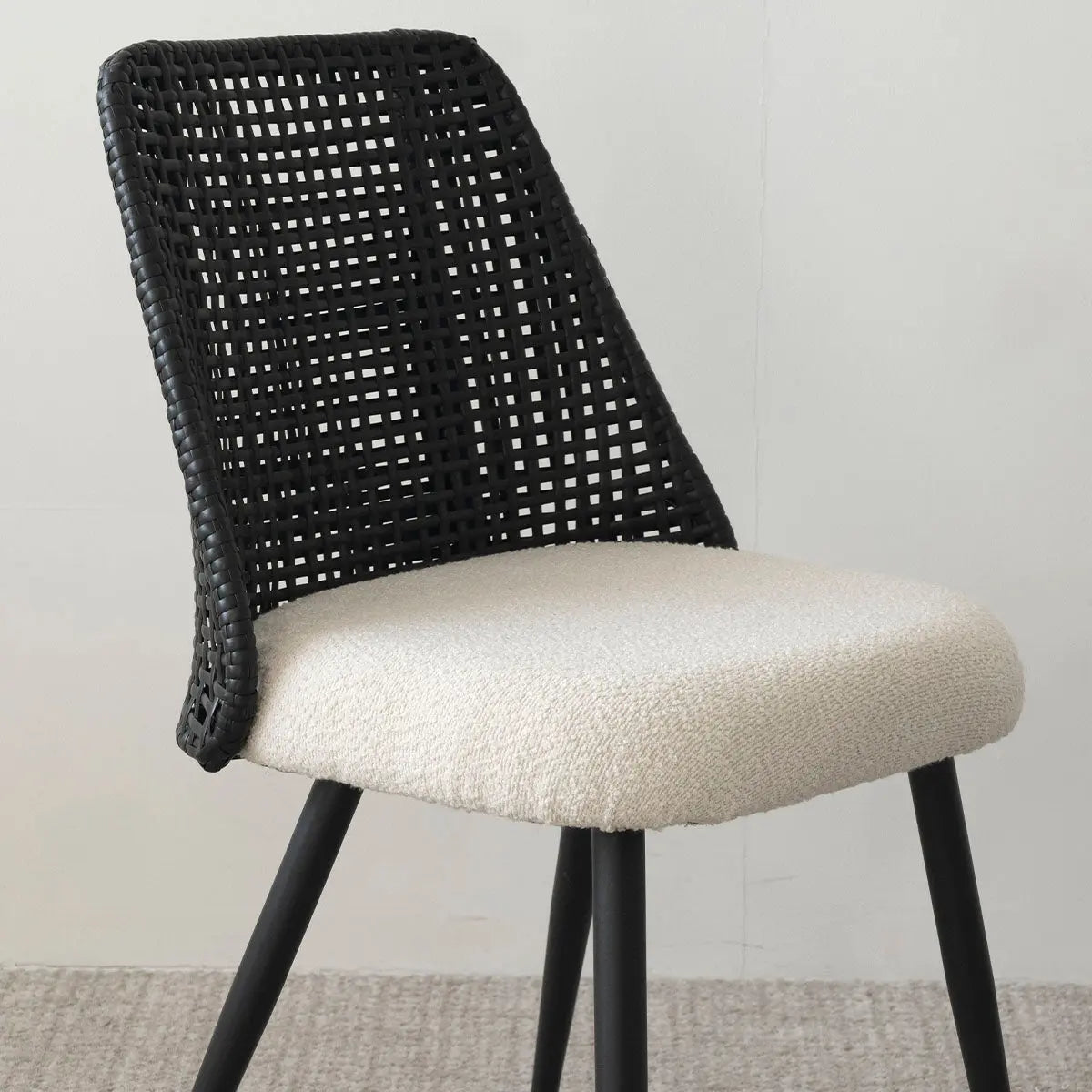 Modern Nice Rattan Upholstered Dining Chair on beige carpet with gray wall. Stylish seating option.