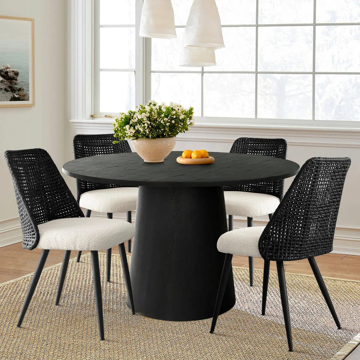 Nice Rattan Upholstered Dining Chair set around black round table, light wall, wood flooring, dining room.