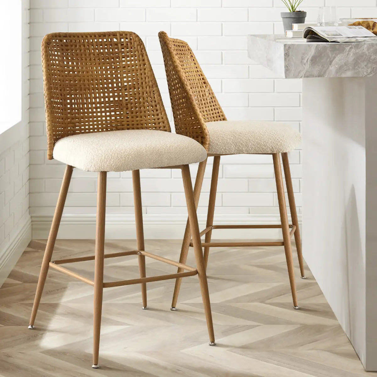 Nice 27" Rattan Upholstered Counter Stools in kitchen, white brick wall, herringbone wood floor.