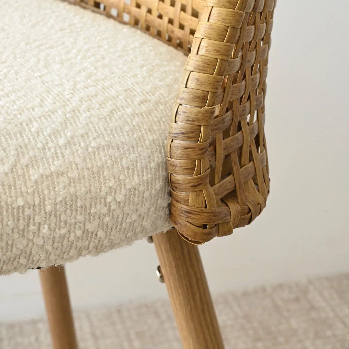 Close-up of Nice Modern Upholstered Rattan Stool with natural wood legs and textured beige fabric.