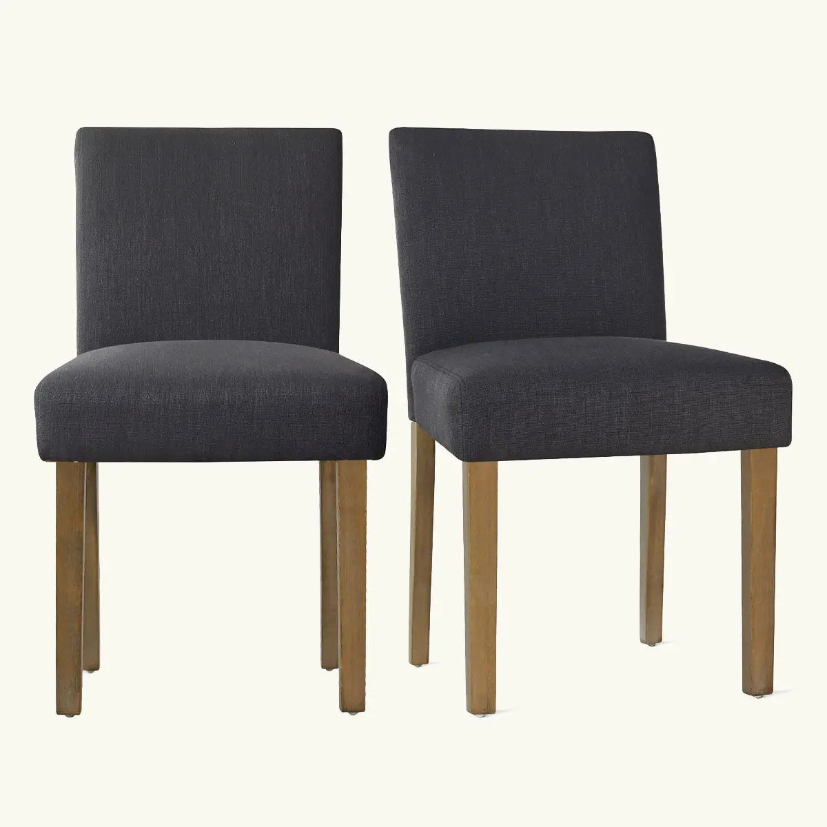 Two North Upholstered Dining Chairs with dark fabric and wooden legs, against a light background.