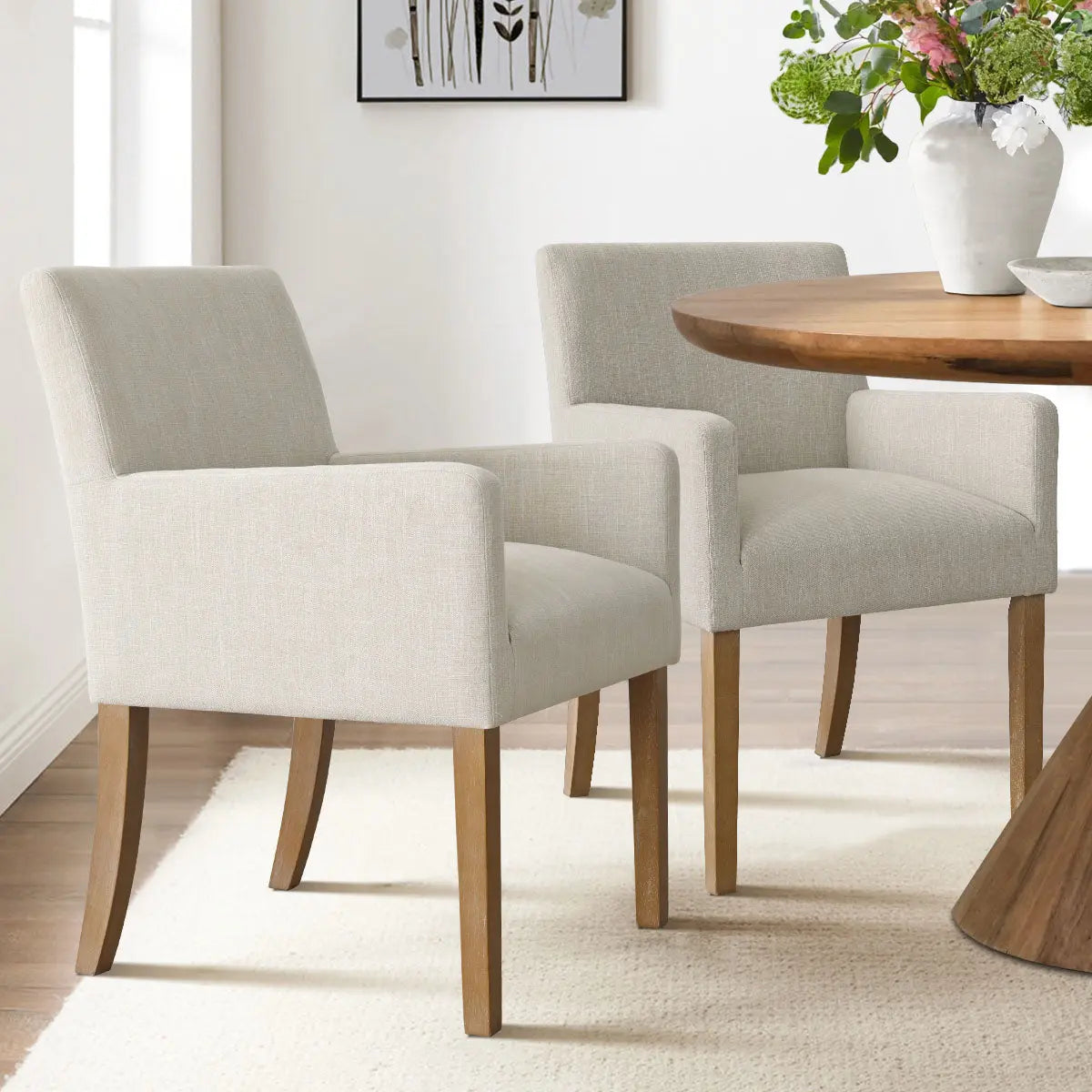 North Modern Boucle Armchair in neutral dining room, wooden table, white rug, decorative painting.