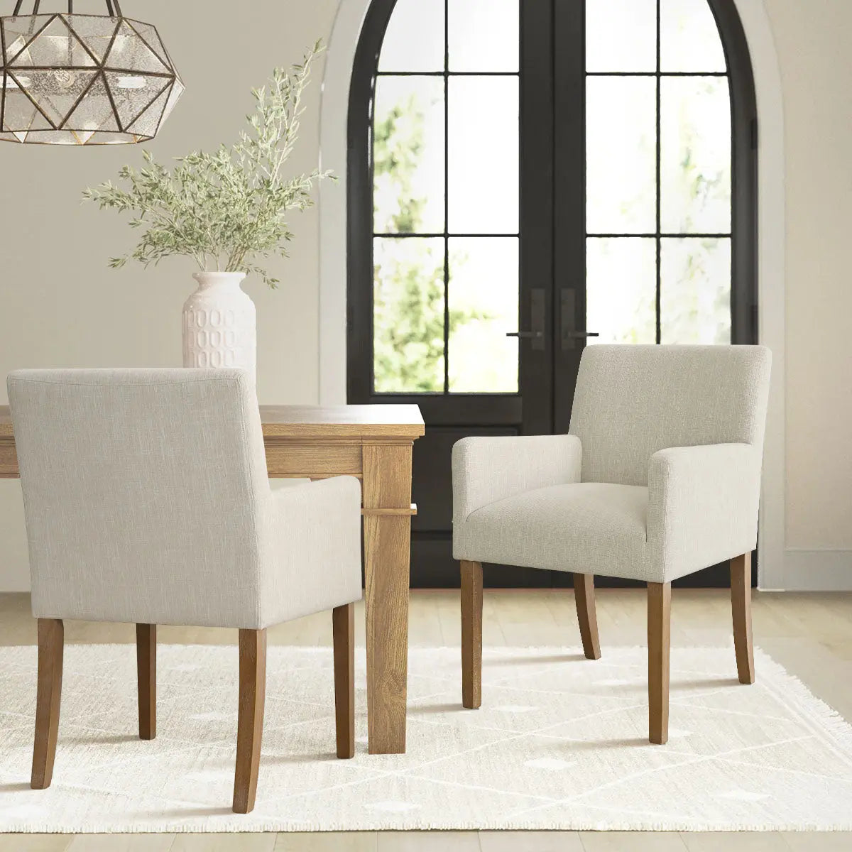 North Modern Boucle Upholstered Armchair in dining room with beige walls, wooden table, and white rug.