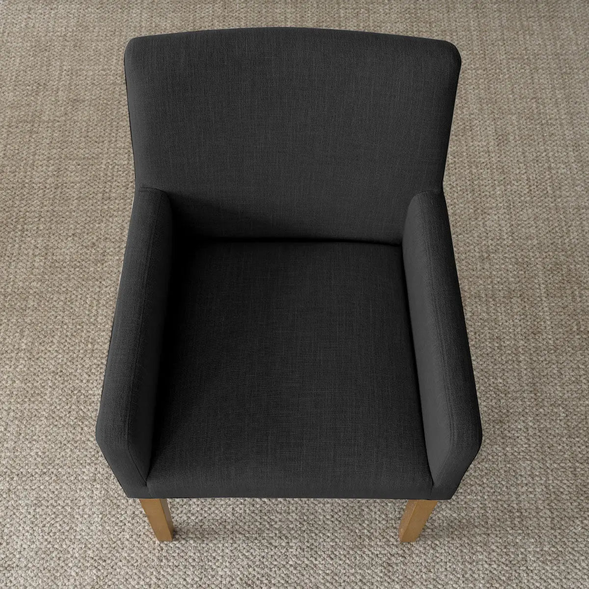 North Modern Boucle Armchair in dark fabric on textured carpet.