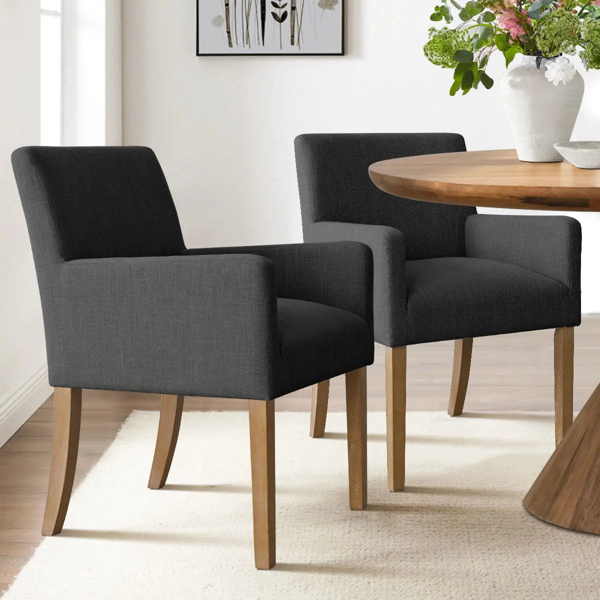 North Modern Boucle Armchair pair complementing wooden dining table, white rug, bright dining room.