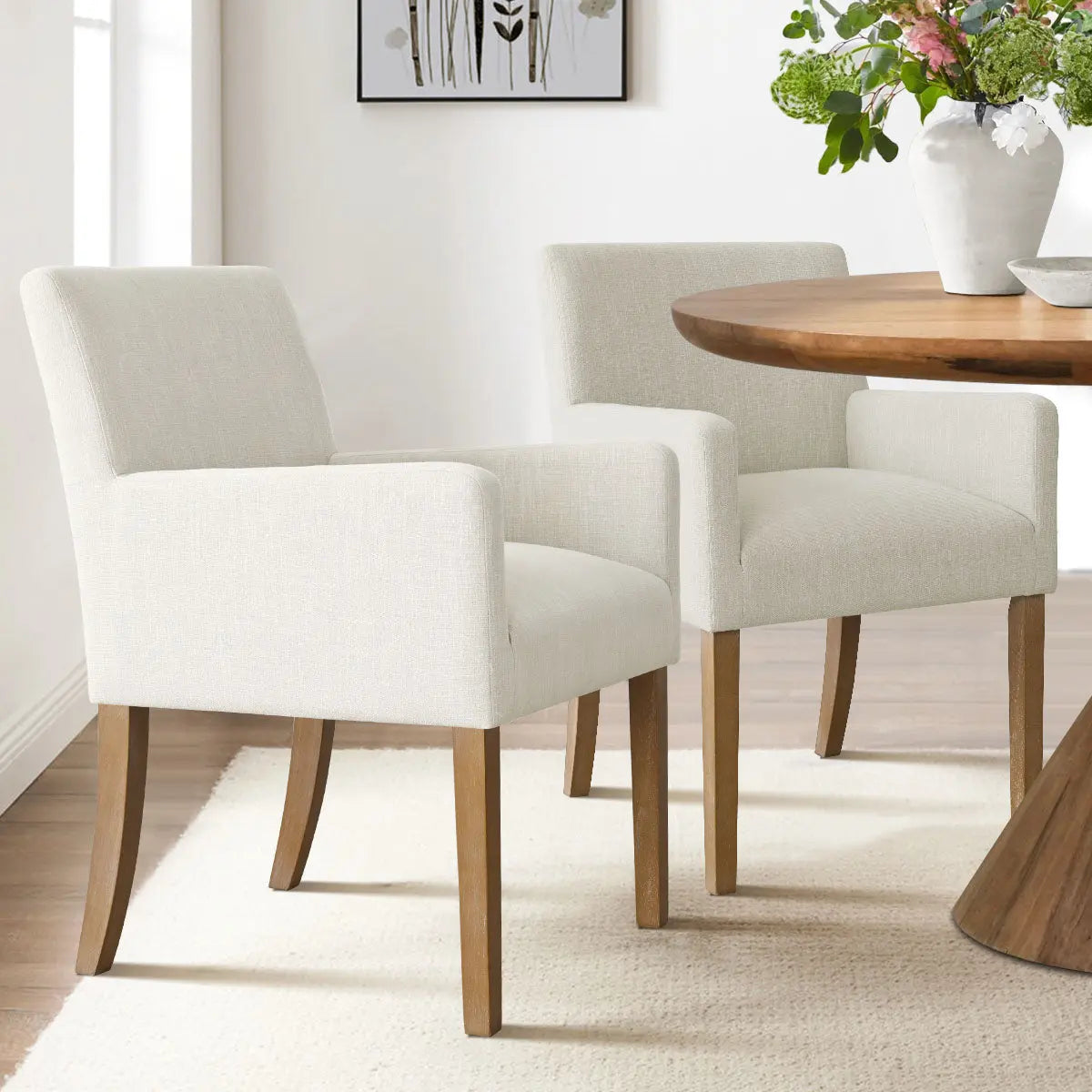 North Modern Boucle Armchair with light wood dining table in neutral-tone dining room with rug.