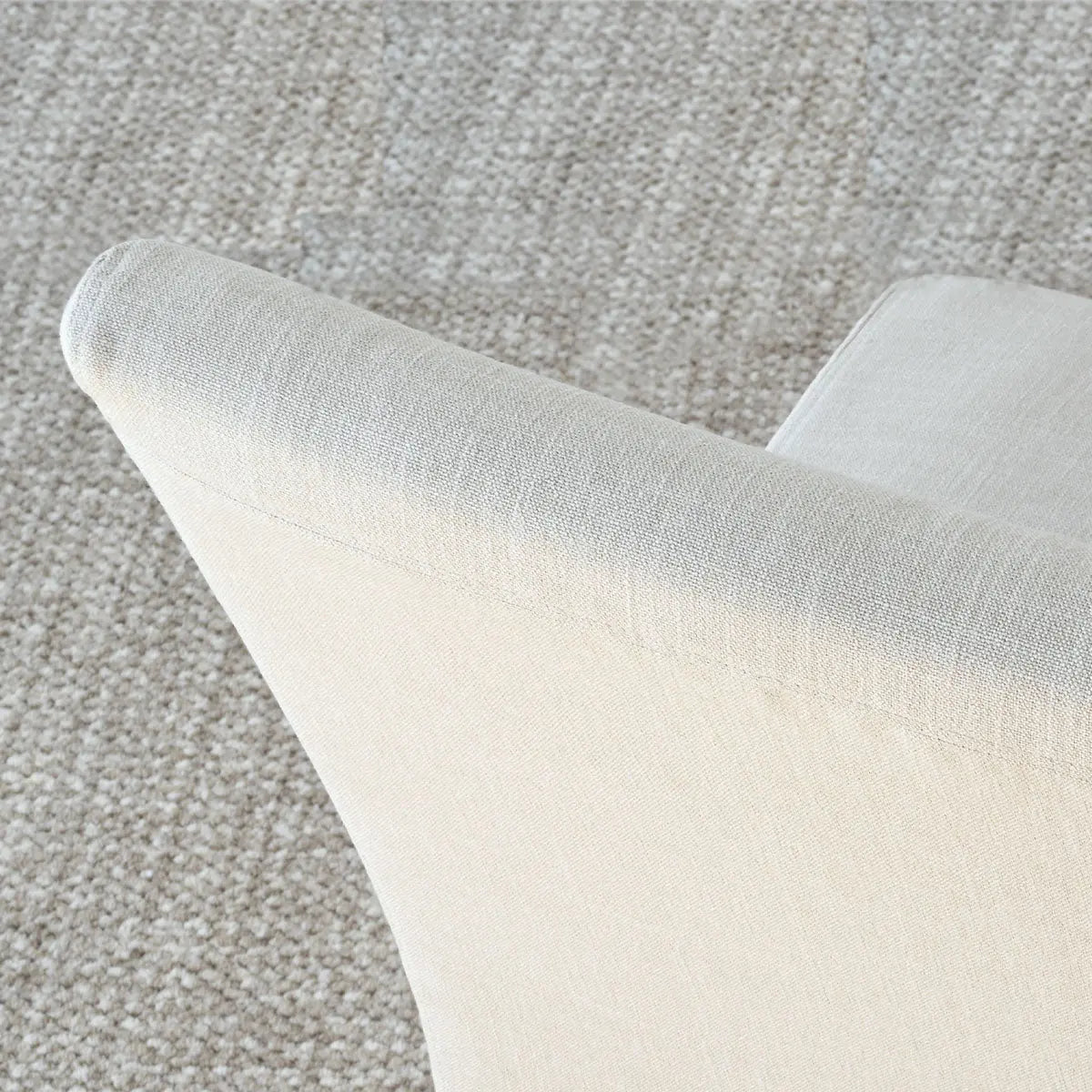 North Beige Dining Chair Corner View, Upholstered Slipcovers on Textured Carpet Floor, Detail Focus.