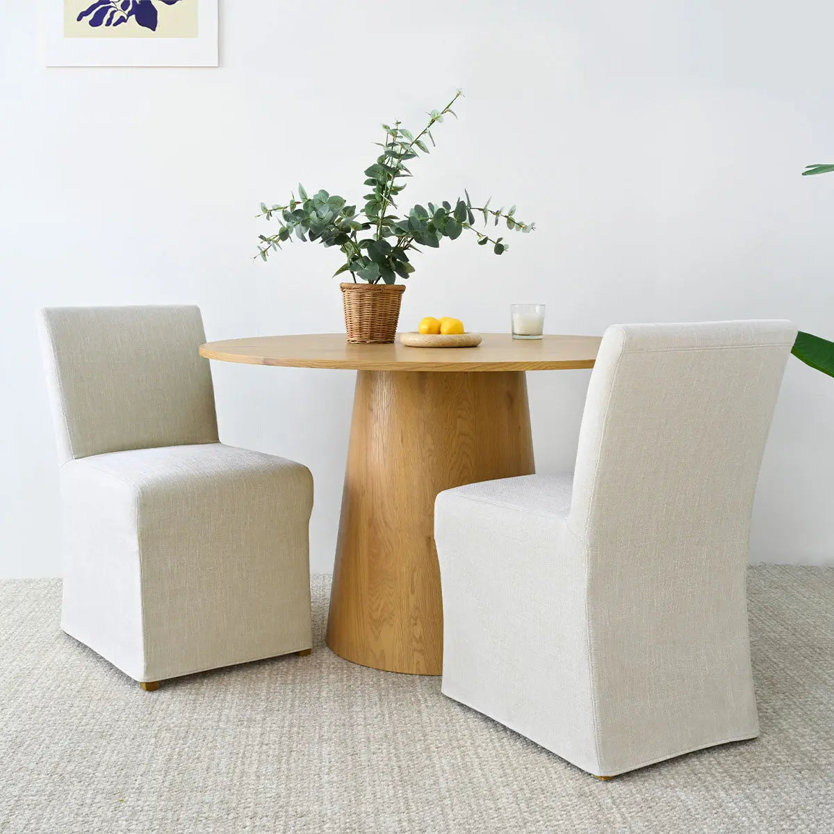 North Beige Fully Upholstered Dining Chair with oak table, beige carpet, art decor, light walls.