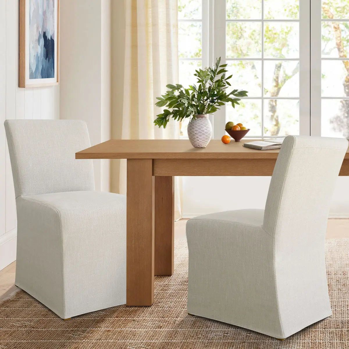 North Beige dining chair with removable slipcovers in bright dining room, wooden table, neutral decor.