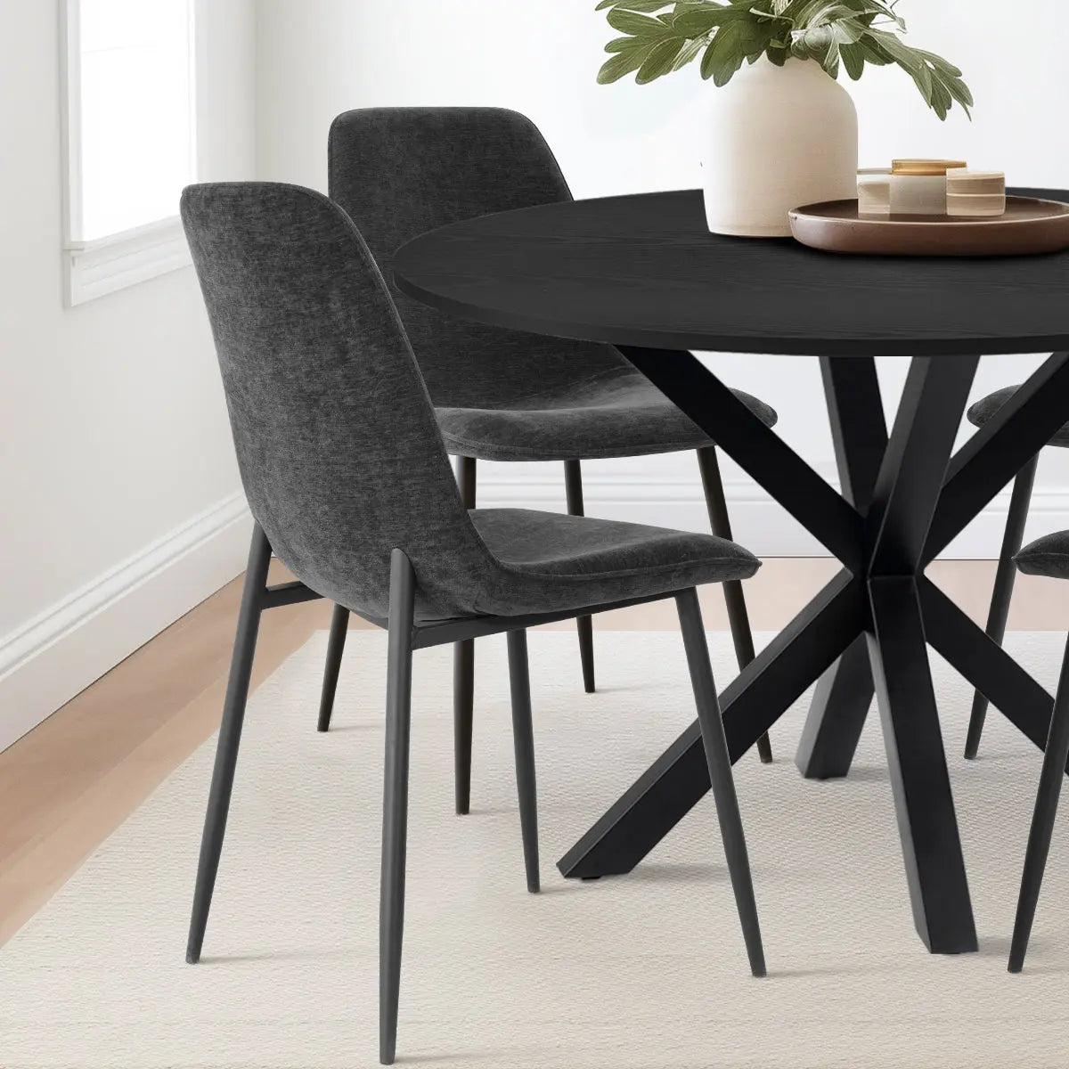 Oliver & Oslo Round Dining Table Set with dark chairs, light walls, wood floor, modern dining room.