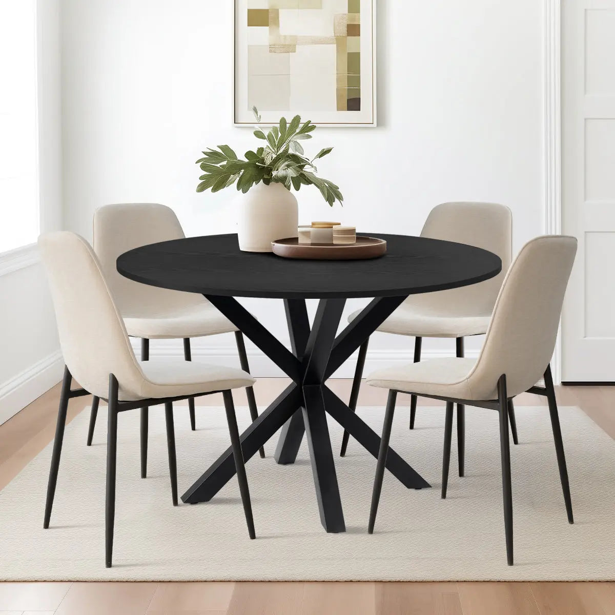 Oliver & Oslo Round Dining Table Set with beige chairs, wood flooring, and abstract wall art.