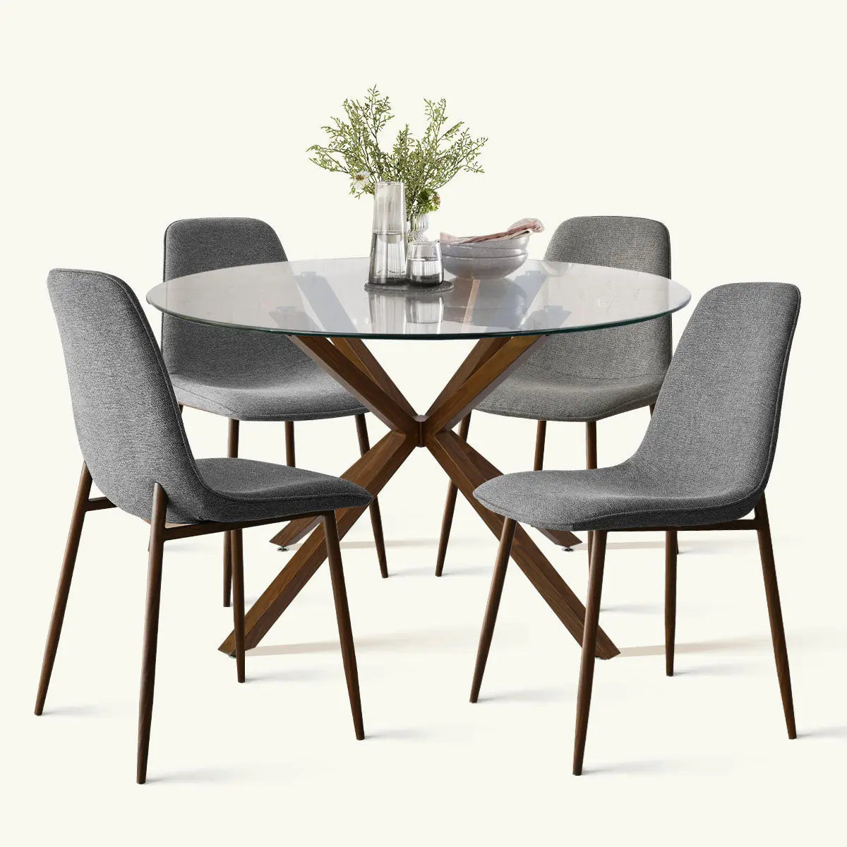 Oliver & Oslo glass round dining table set with gray chairs, wooden legs, in modern room setting.