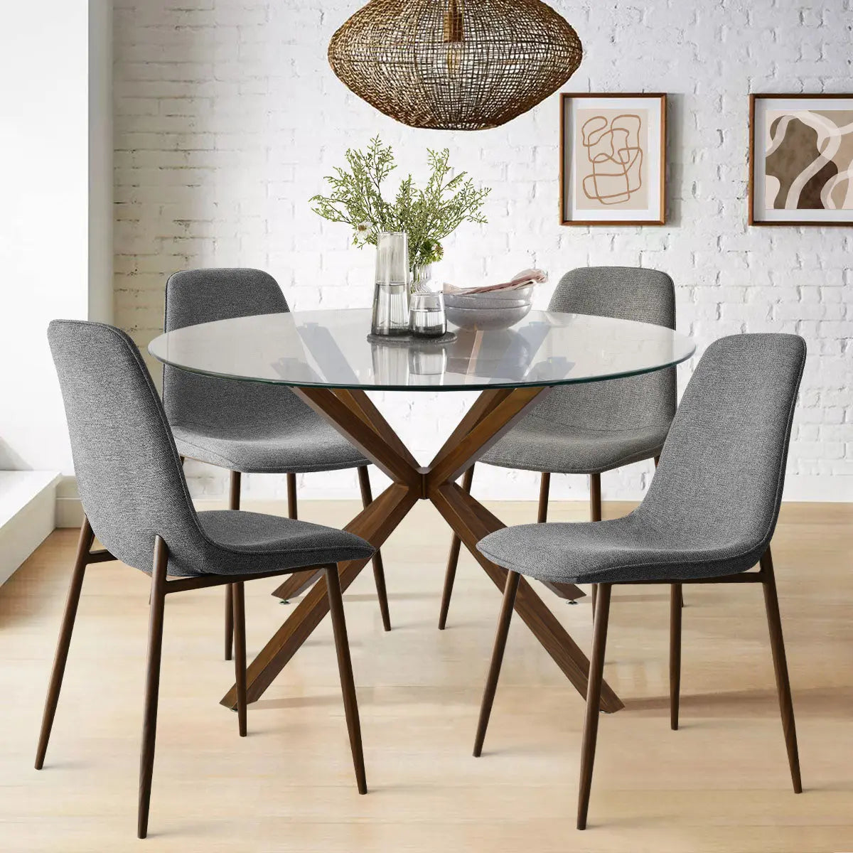 Oliver & Oslo Glass Round Dining Table Set with gray chairs, white brick wall, and wood flooring.