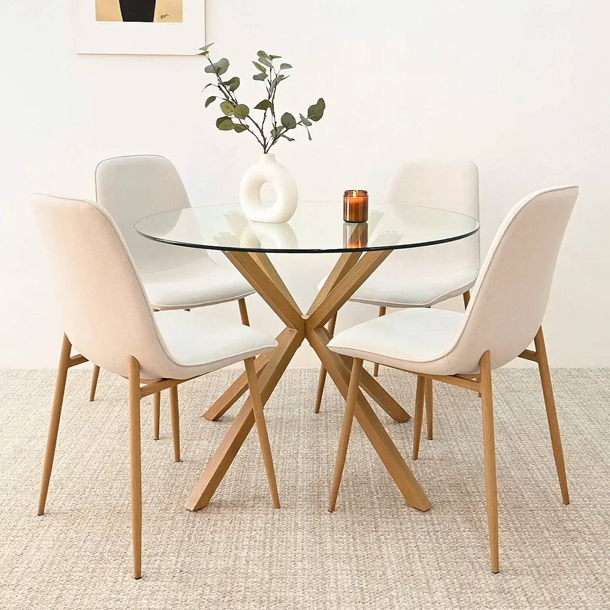 Oliver & Oslo glass round dining table set, beige chairs, textured carpet, minimalist dining room decor.