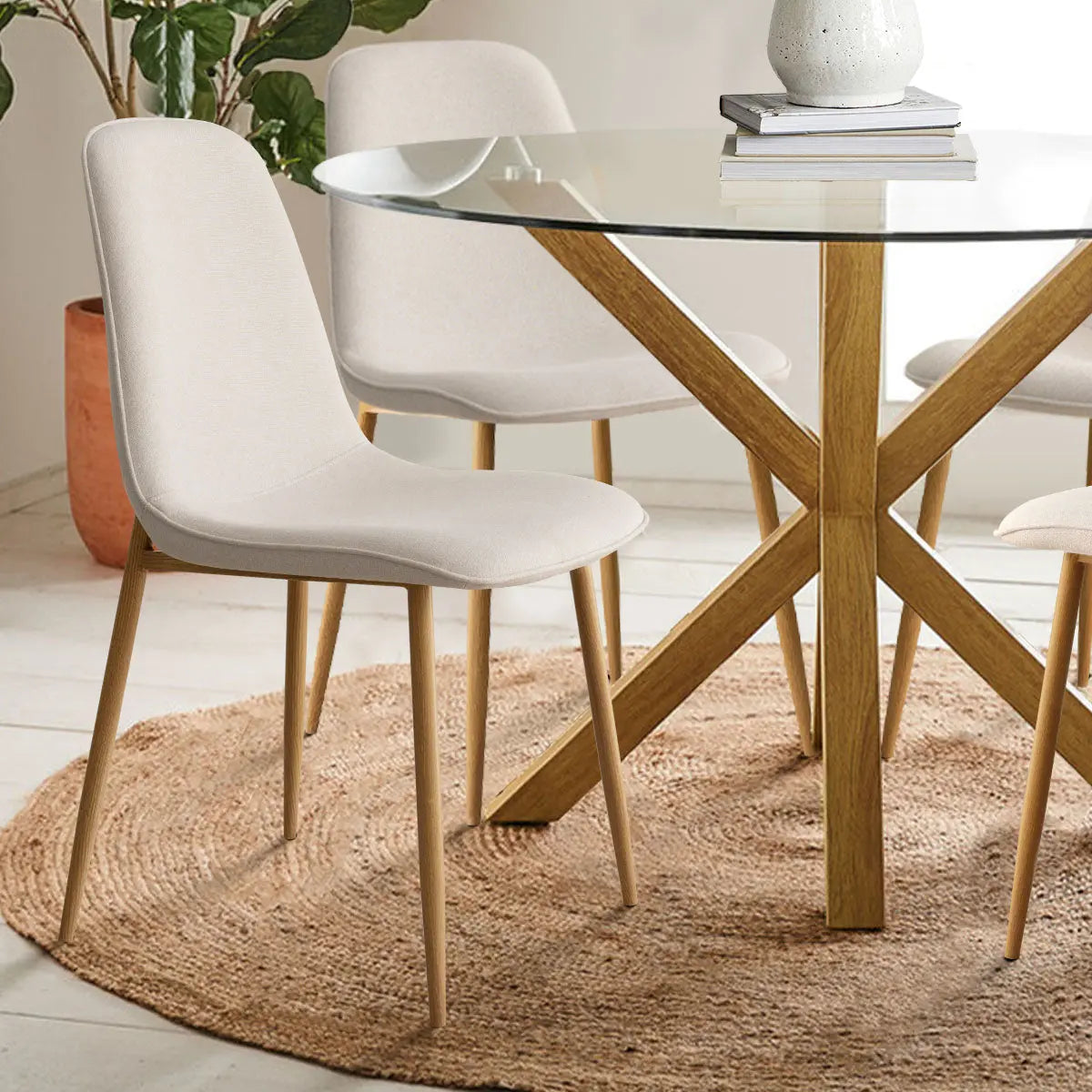 Oliver & Oslo Glass Round Dining Table Set, wooden base, beige chairs, woven rug, living room.