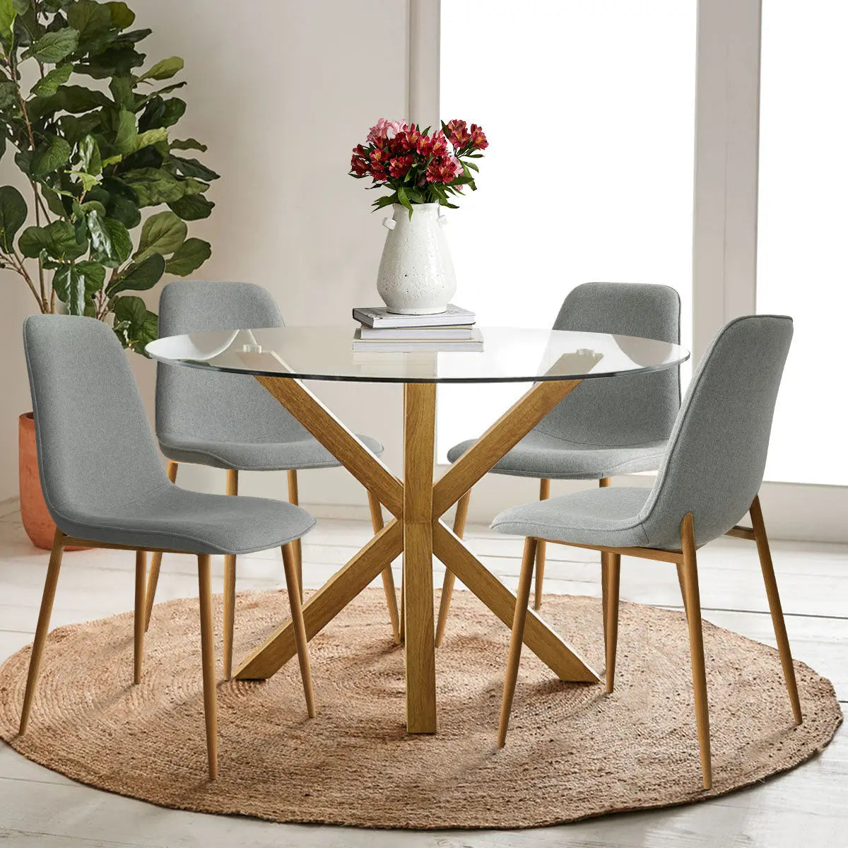 Oliver & Oslo Glass Round Dining Table Set, gray chairs, wooden flooring, dining room, plant decor.