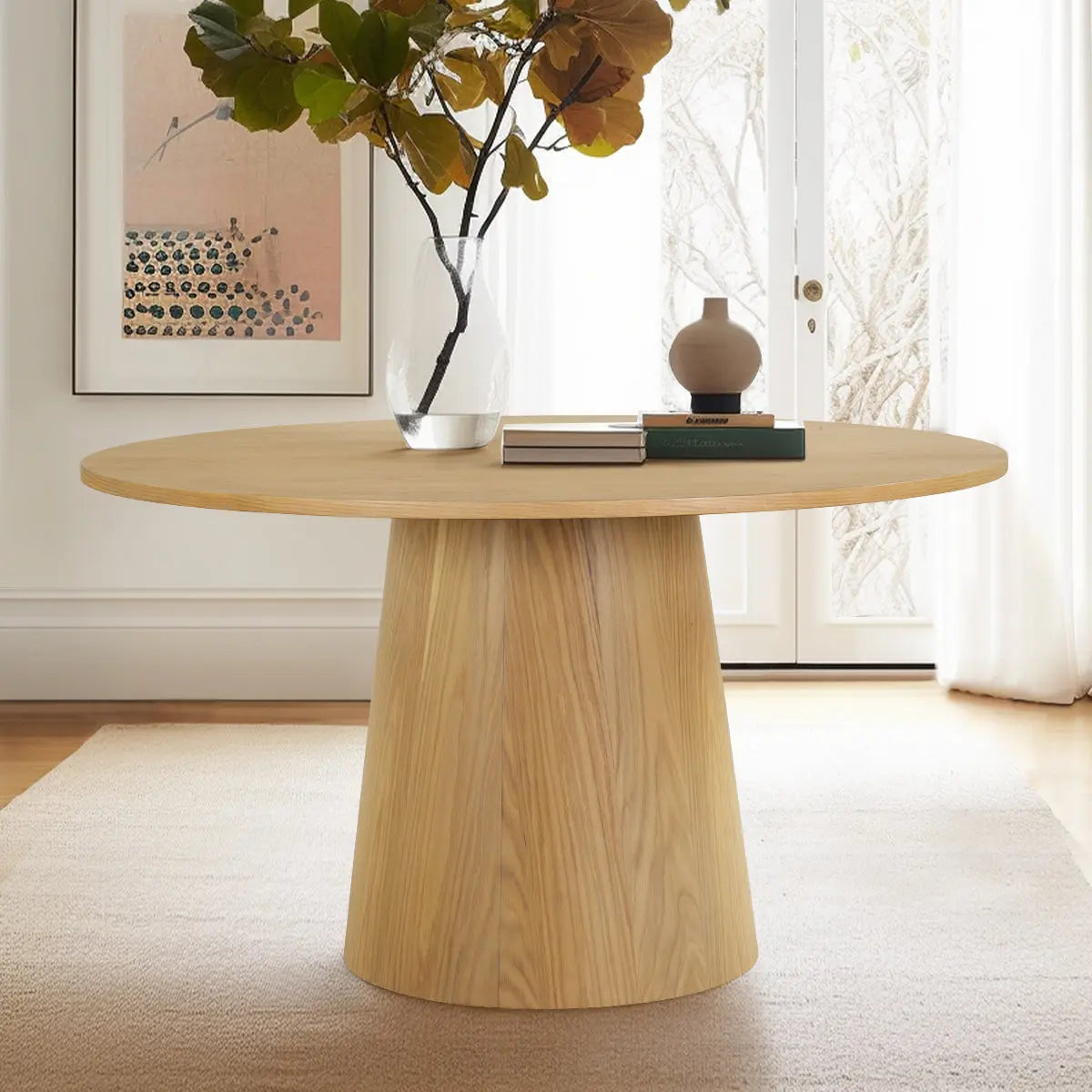 Orchid Solid Oak Round Pedestal Dining Table in bright room, beige rug, modern artwork on wall.