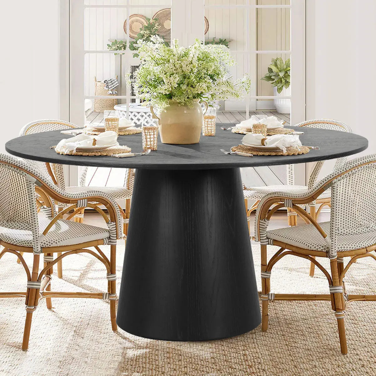 Orchid Oak dining table with wicker chairs, beige walls, and textured rug in a bright room.