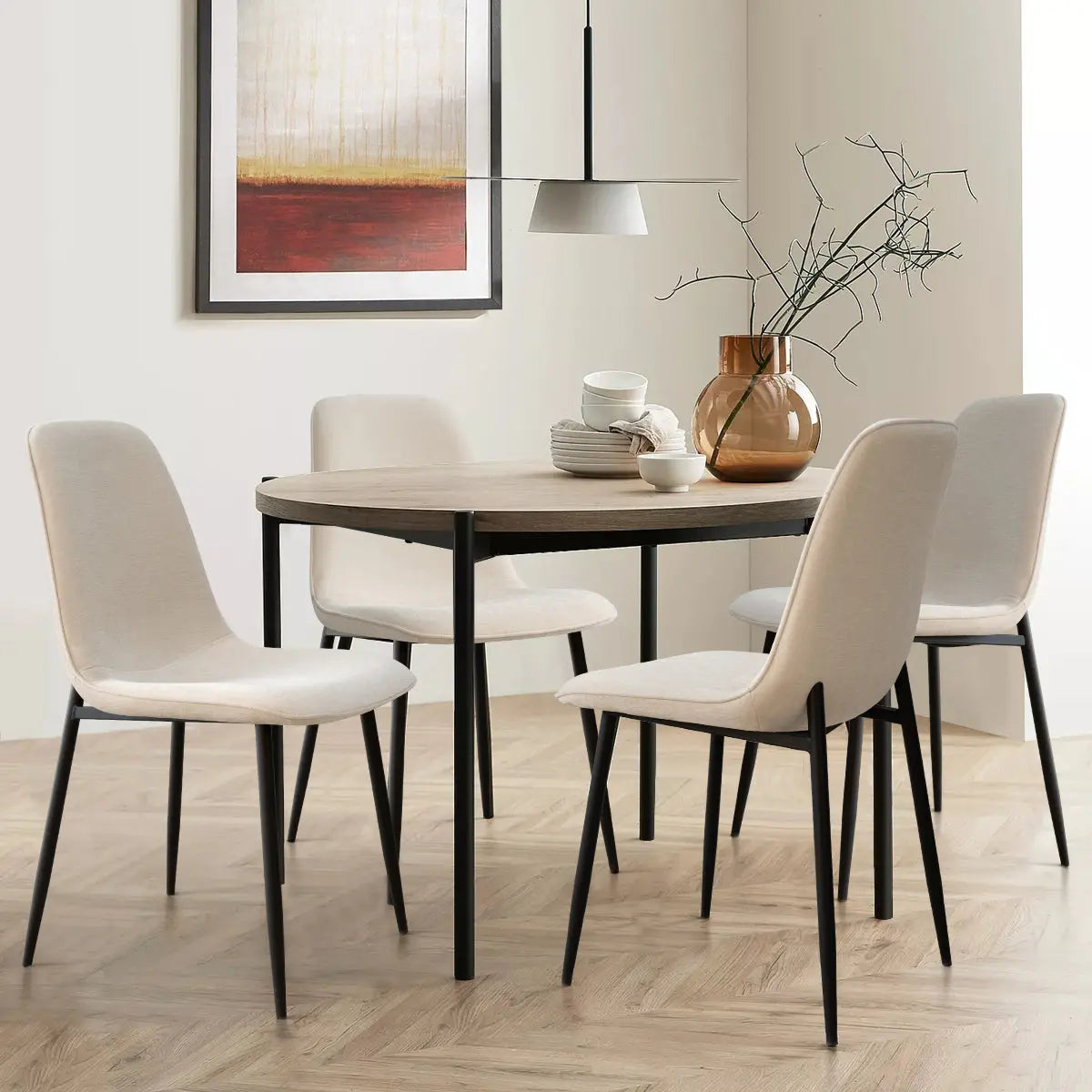 Oslo Modern Upholstered Dining Chair with wood table, herringbone flooring, and abstract wall art.