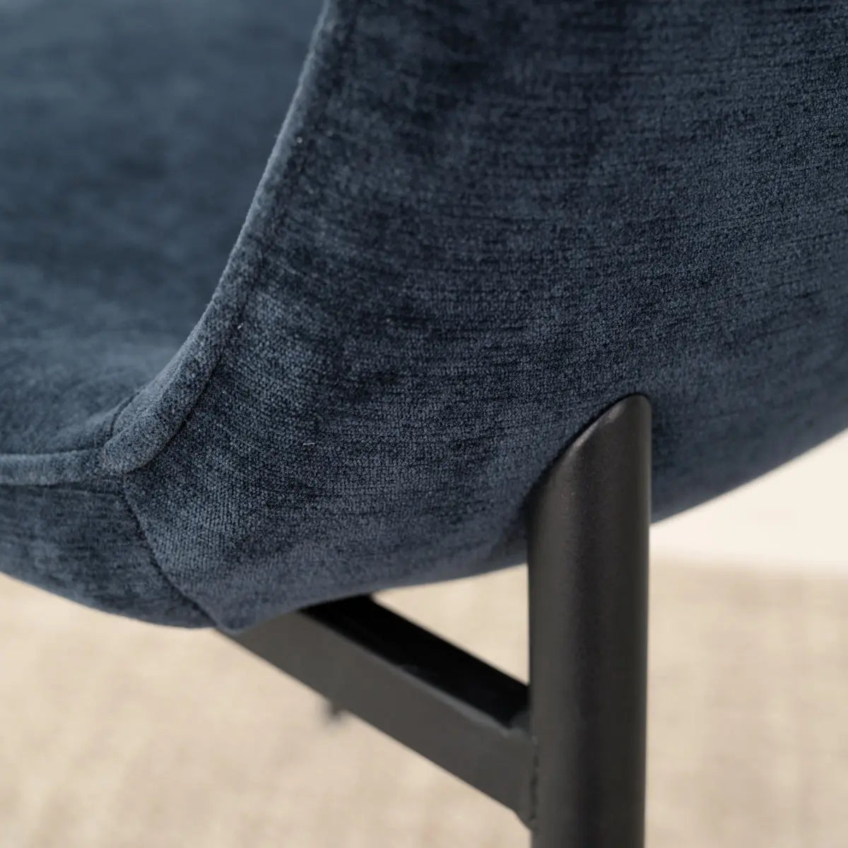 Close-up of Oslo Modern Upholstered Dining Chair, featuring dark blue fabric and metal legs.