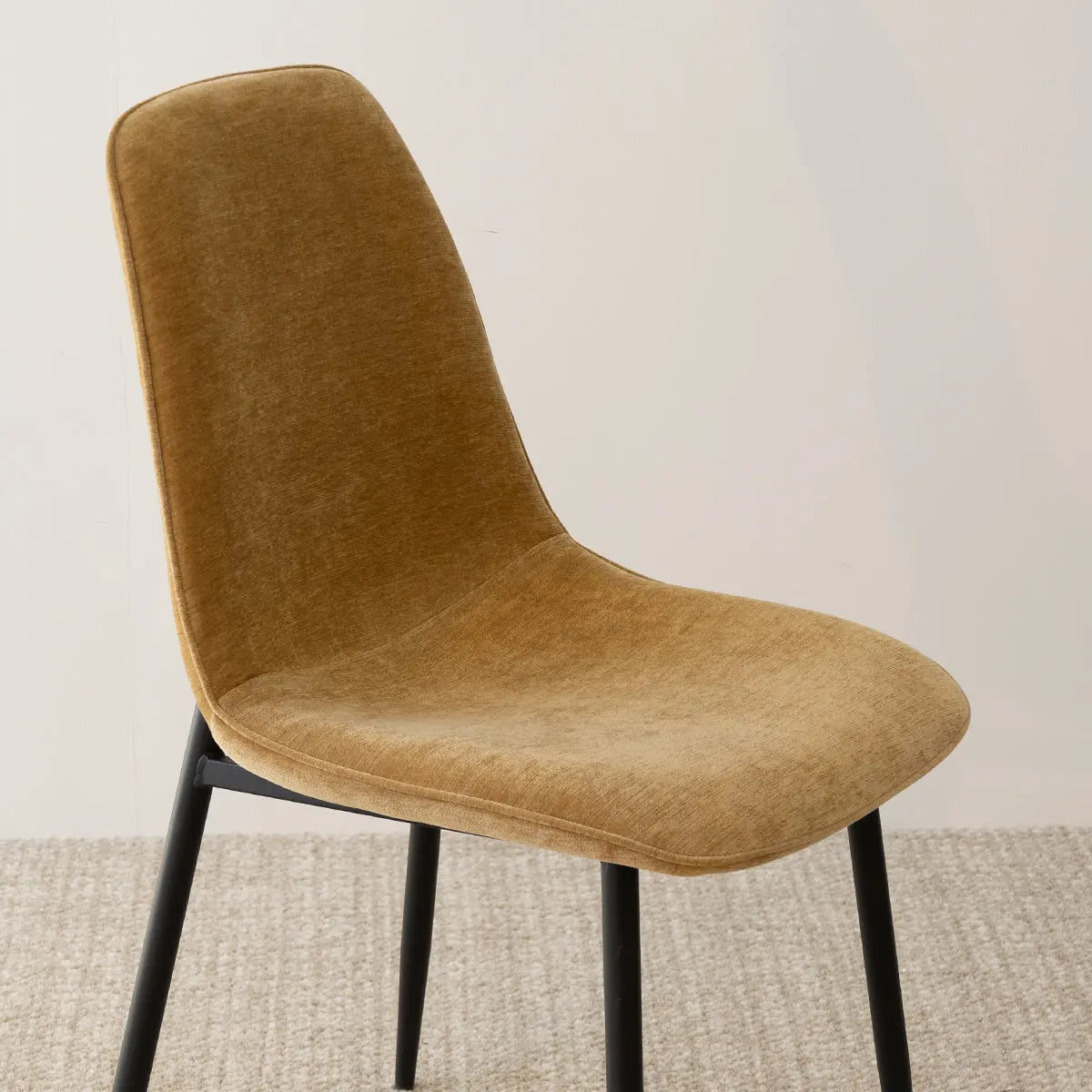 Oslo Modern Upholstered Dining Chair, metal legs, beige upholstery, neutral carpet flooring.