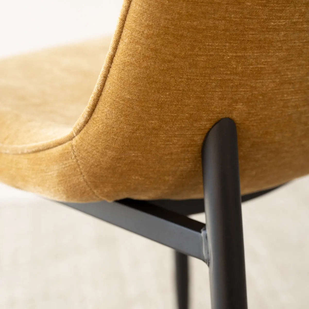 Close-up of Oslo Modern Upholstered Dining Chair with metal legs, beige fabric detail.