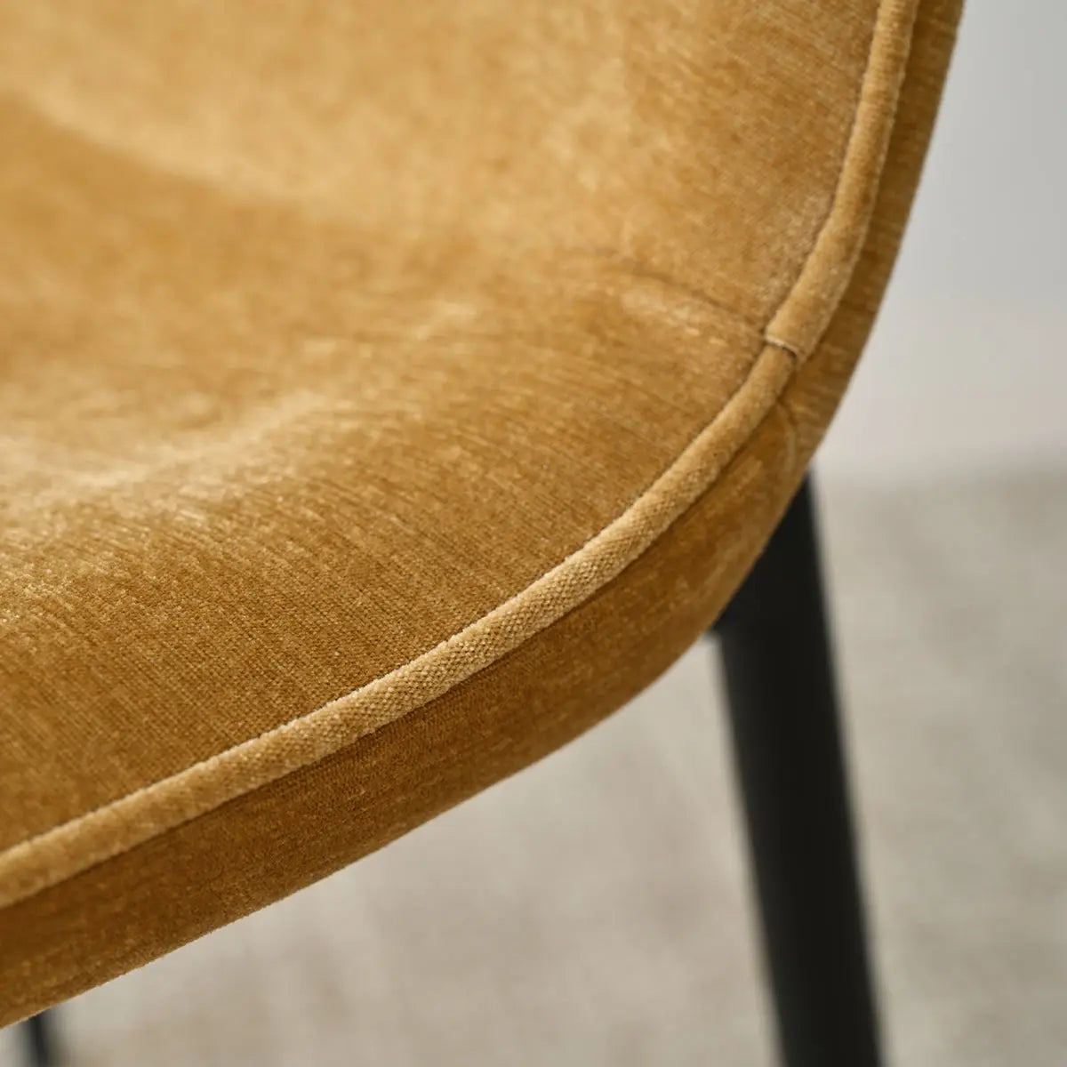 Close-up of Oslo Modern Upholstered Dining Chair with metal legs, textured brown fabric detail.