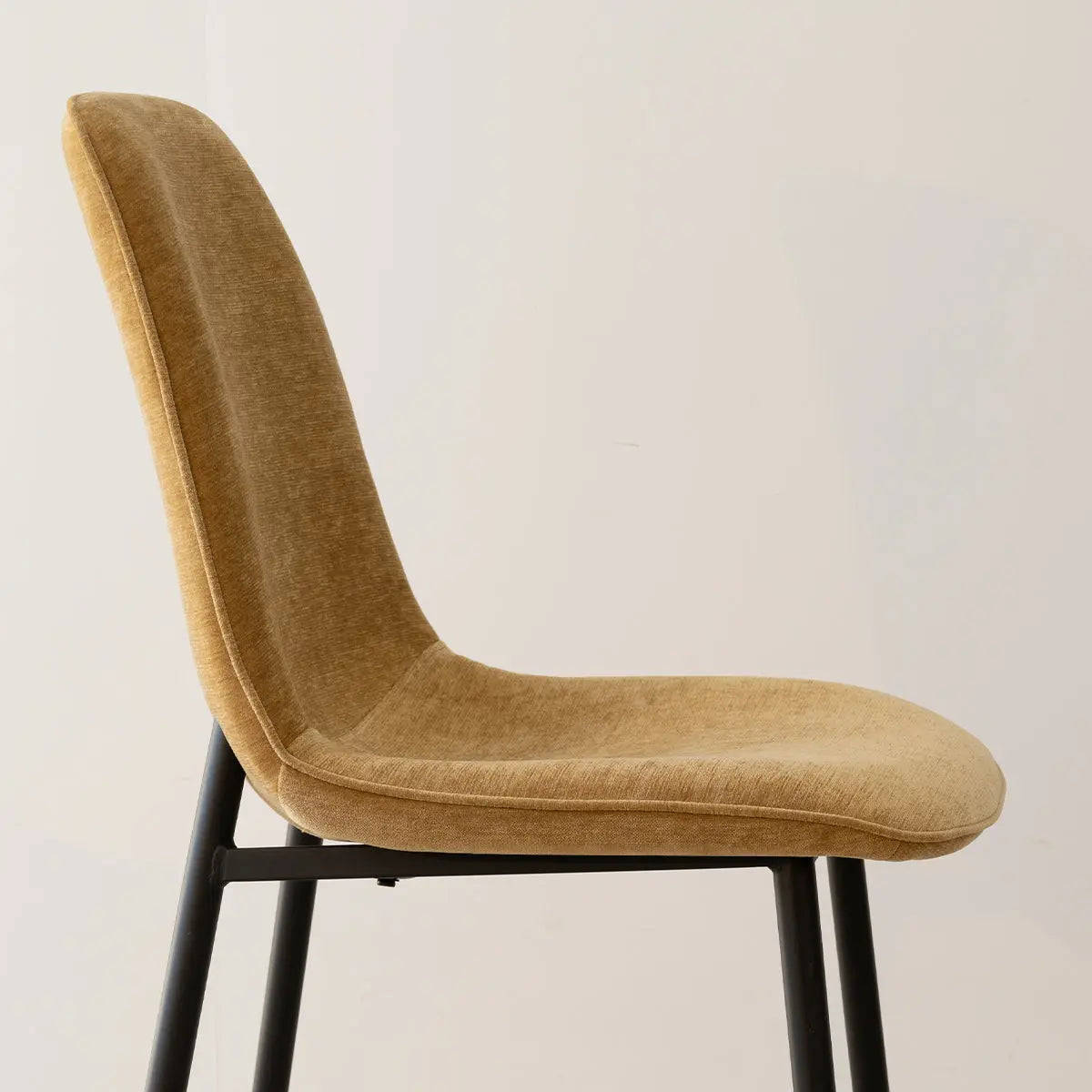 Oslo Modern Upholstered Dining Chair with Metal Legs, beige fabric, black legs, side view.