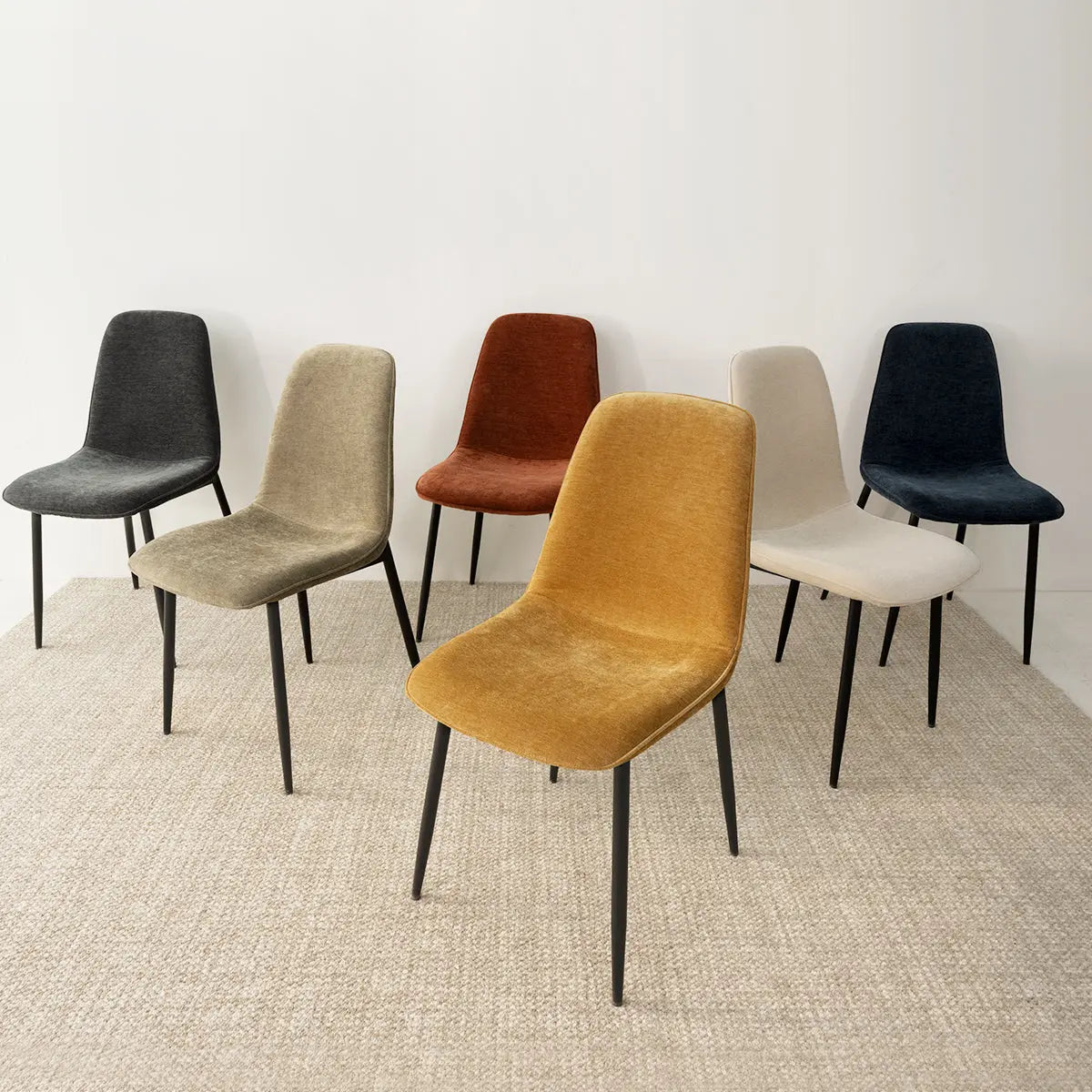 Six colored Oslo Modern chairs on carpet with metal legs in a room setting.