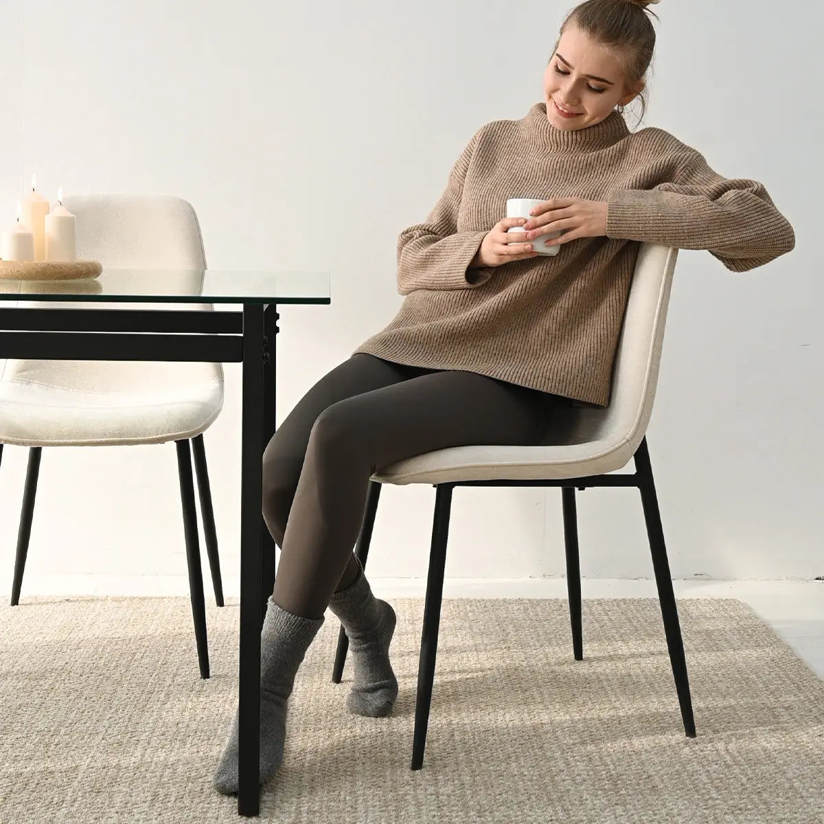 Woman enjoying coffee on Oslo Modern Upholstered Dining Chair, glass dining table, neutral decor.