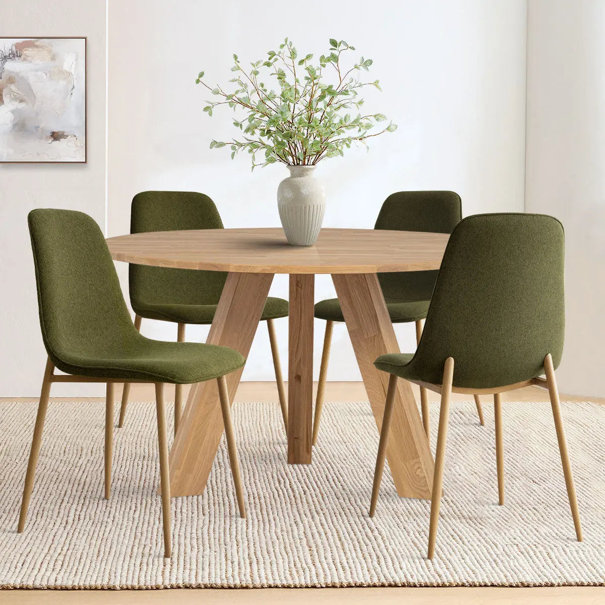 Oslo Modern Chenille Dining Chairs, oak legs, with round wooden table on woven rug, white wall.