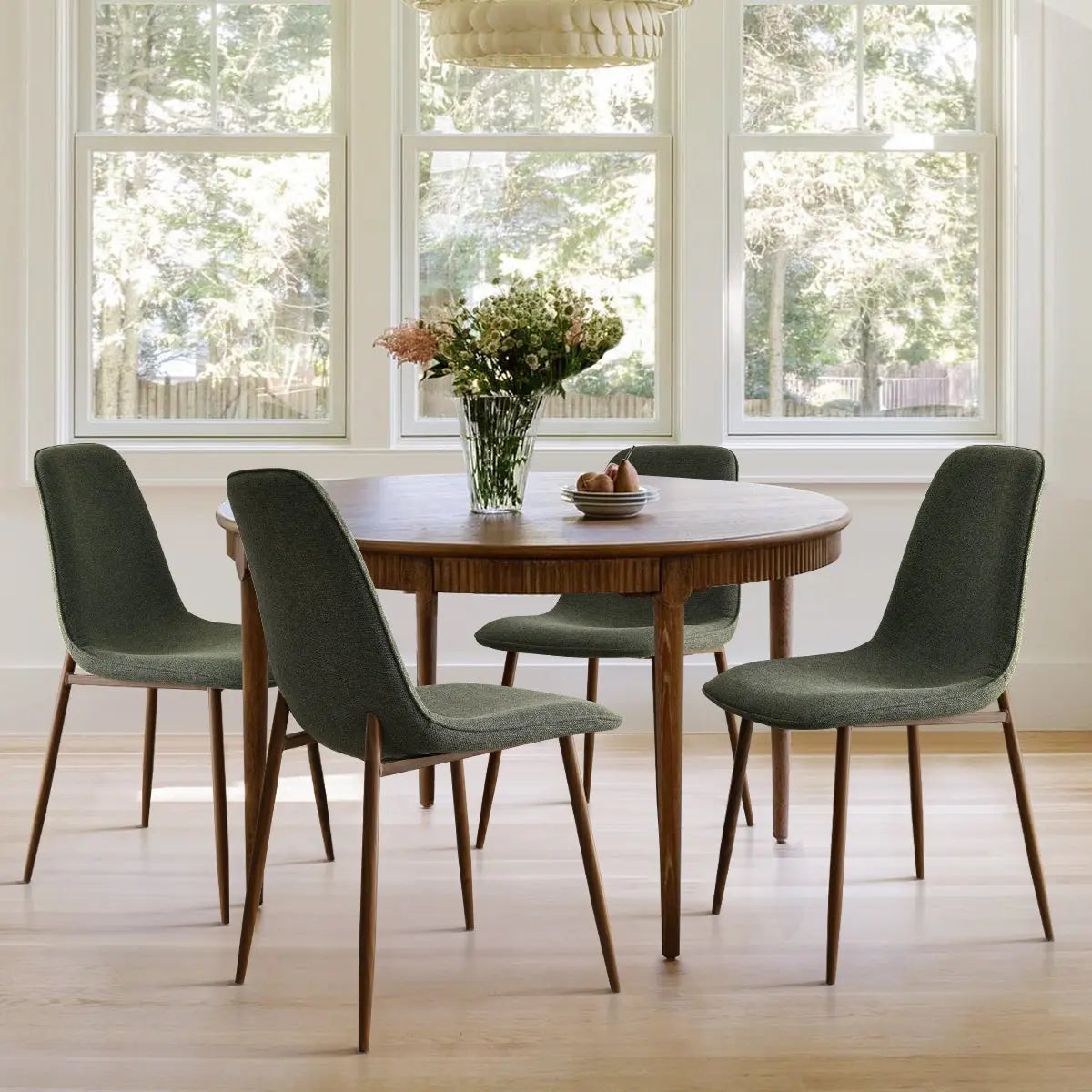 Oslo Modern Upholstered Dining Chair, walnut legs, round table, light hardwood floor, airy room ambiance.