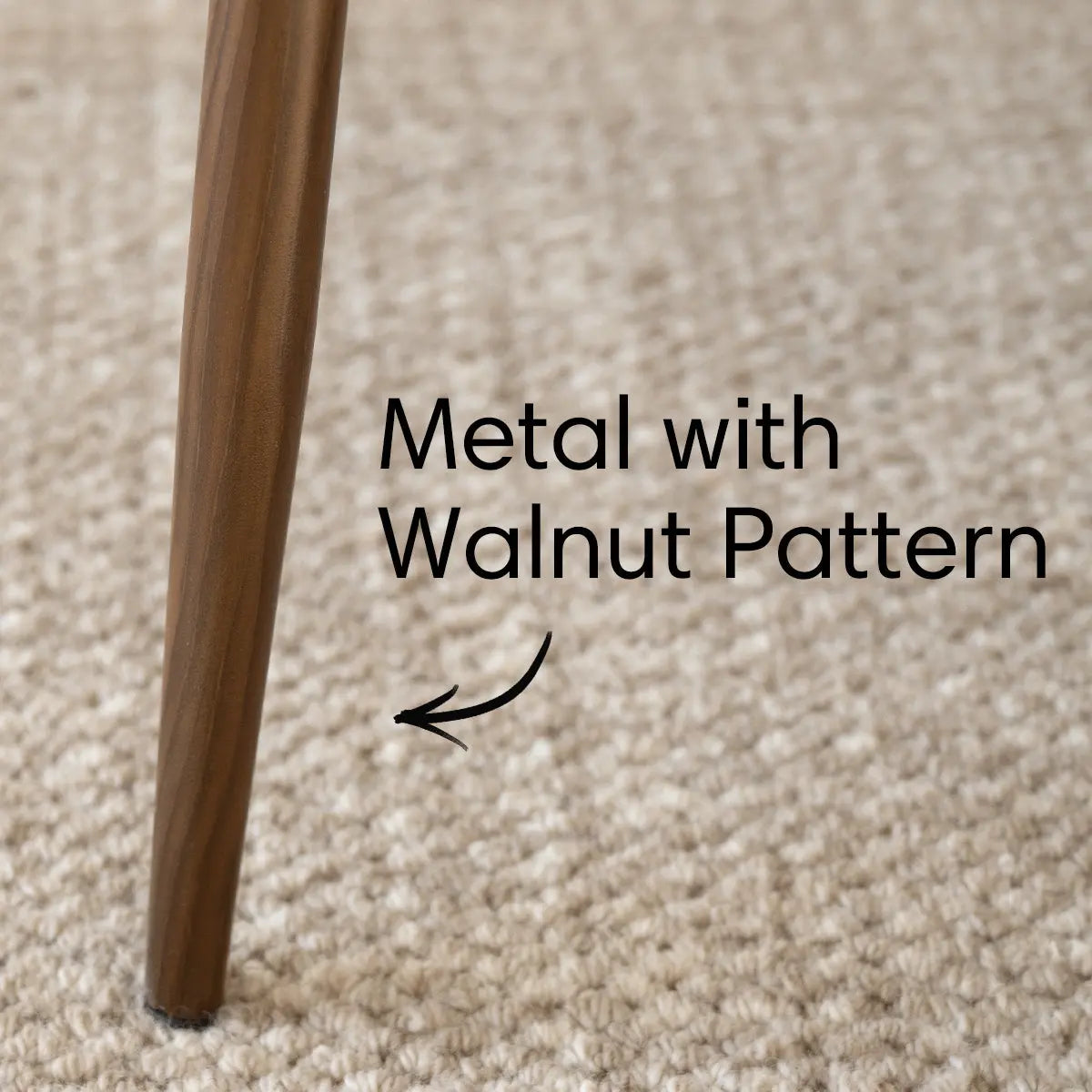 Metal leg with walnut pattern on beige carpet, Oslo chair detail.