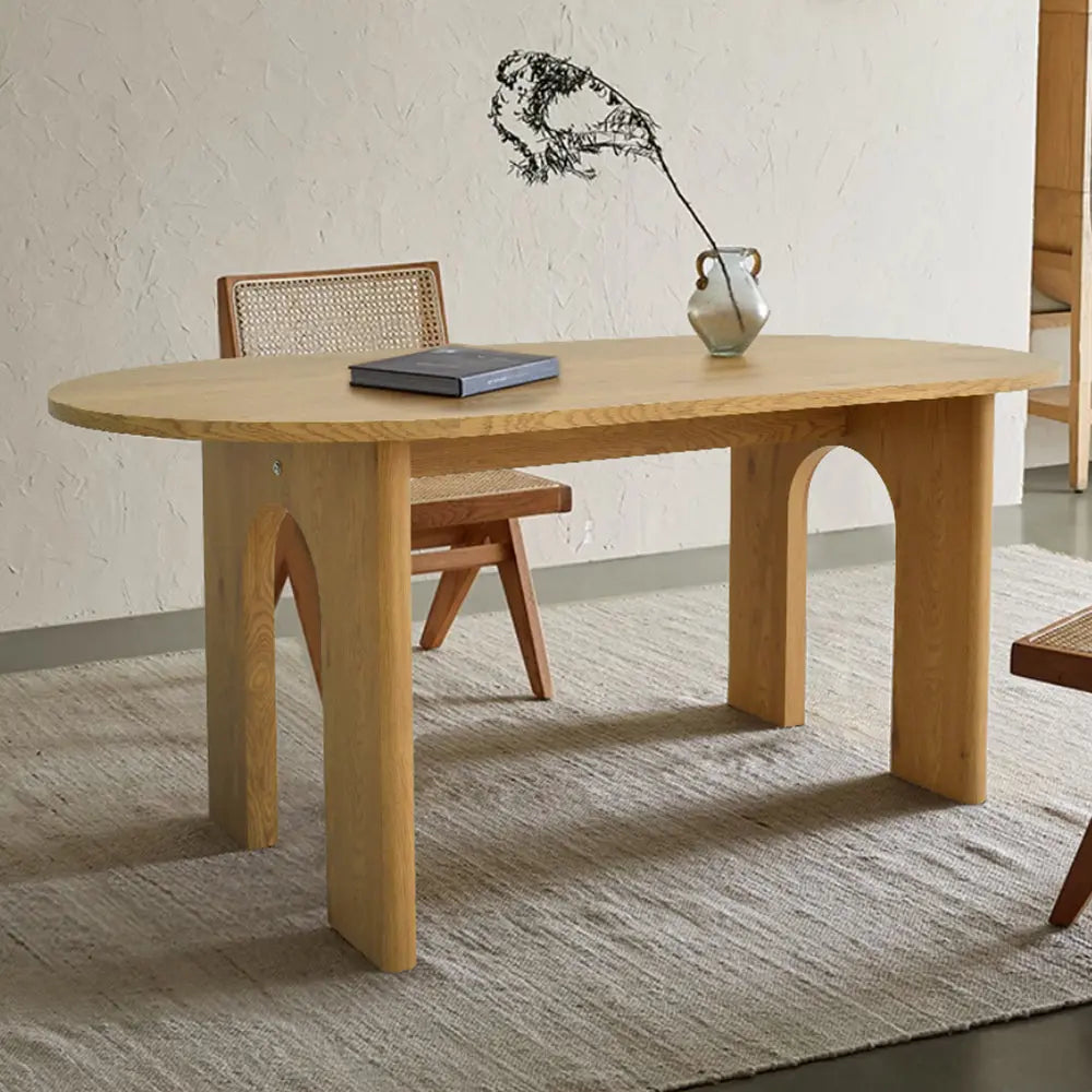 Roma Modern Oval Dining Table with beige wall, wooden chair, and textured rug in dining room.