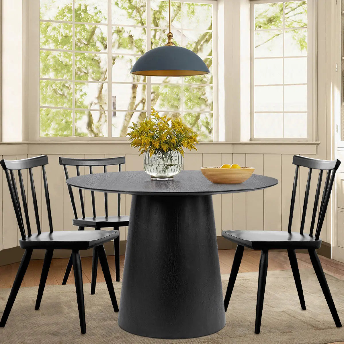 Saigong Oak Round Dining Table with black chairs, wooden flooring, and neutral wall in dining room.