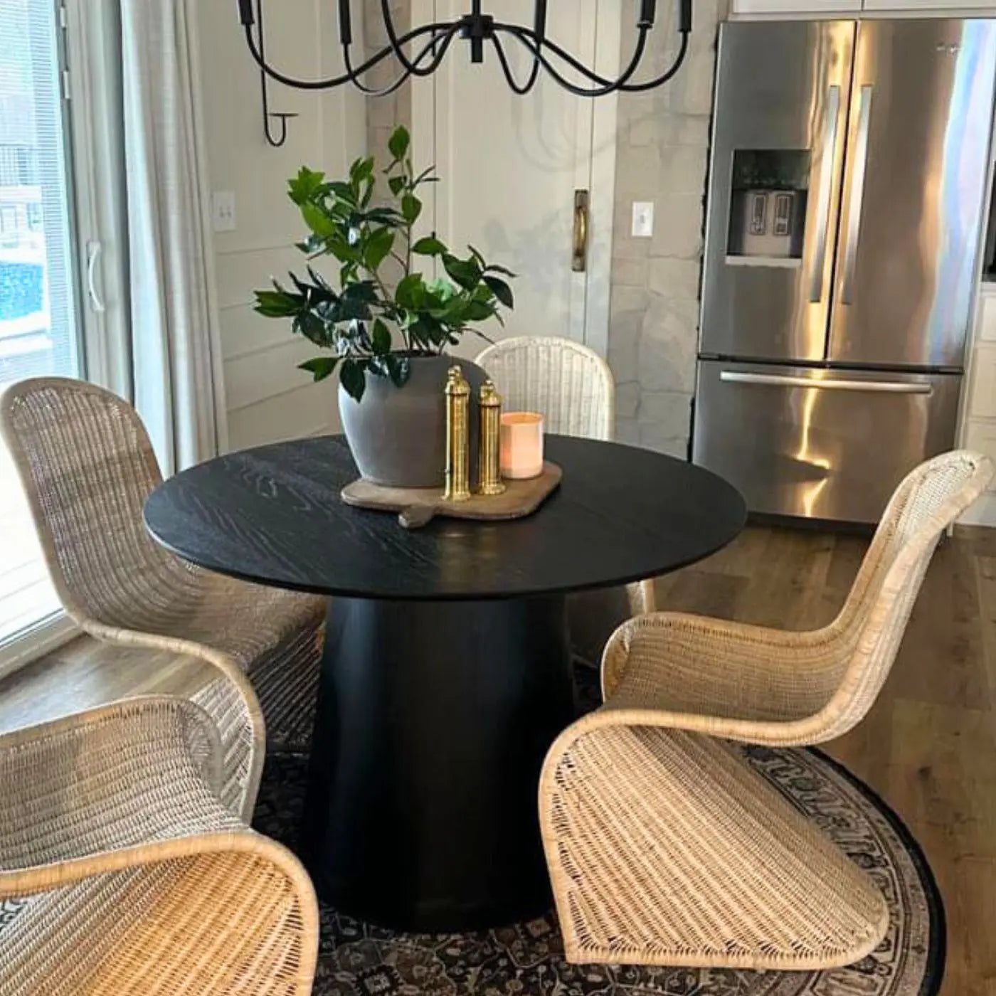 Saigong Oak Round Dining Table with wicker chairs, stainless steel fridge, hardwood floor, and rug.