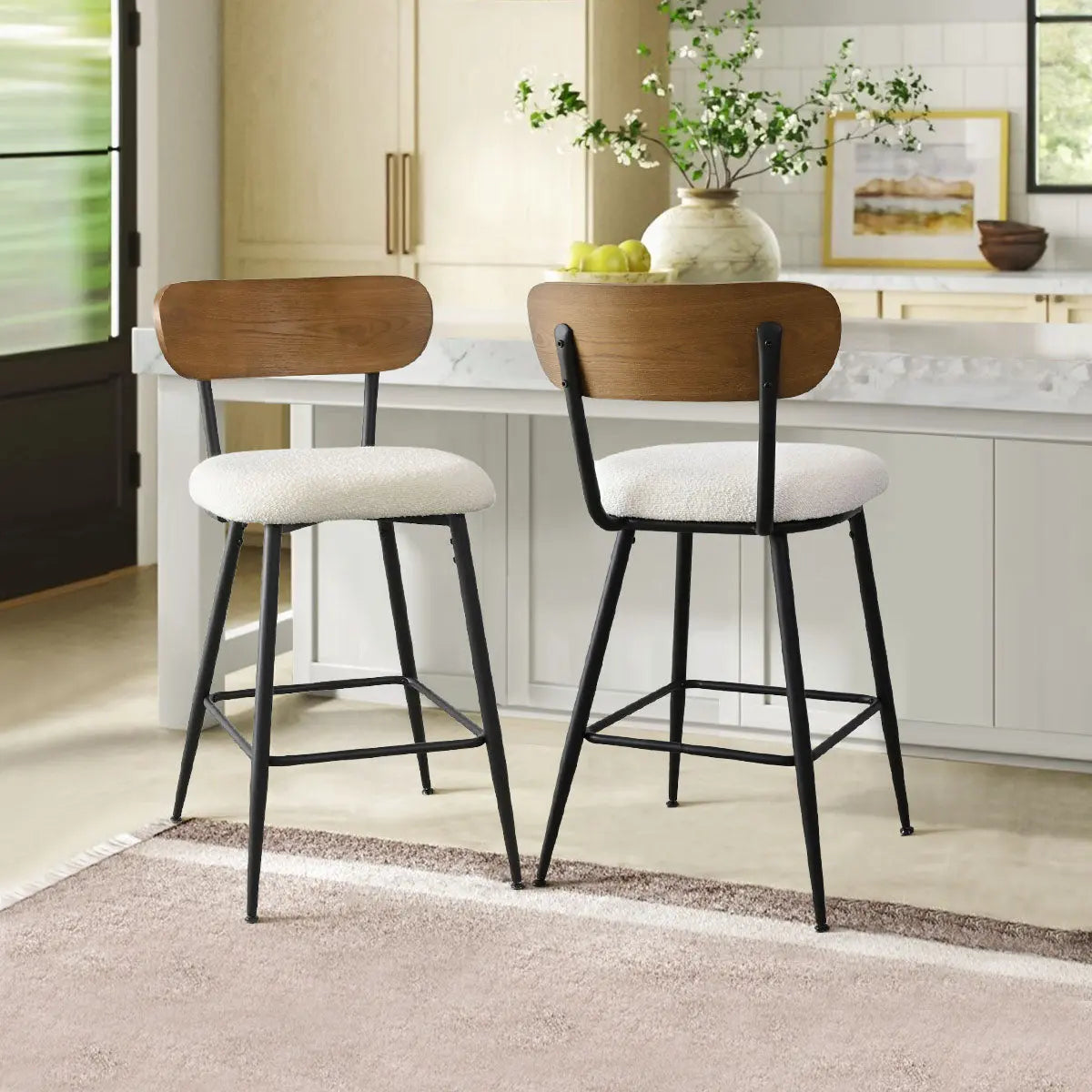 Skagen counter stools in beige boucle with ash back, kitchen island, beige carpet, light wood cabinets.