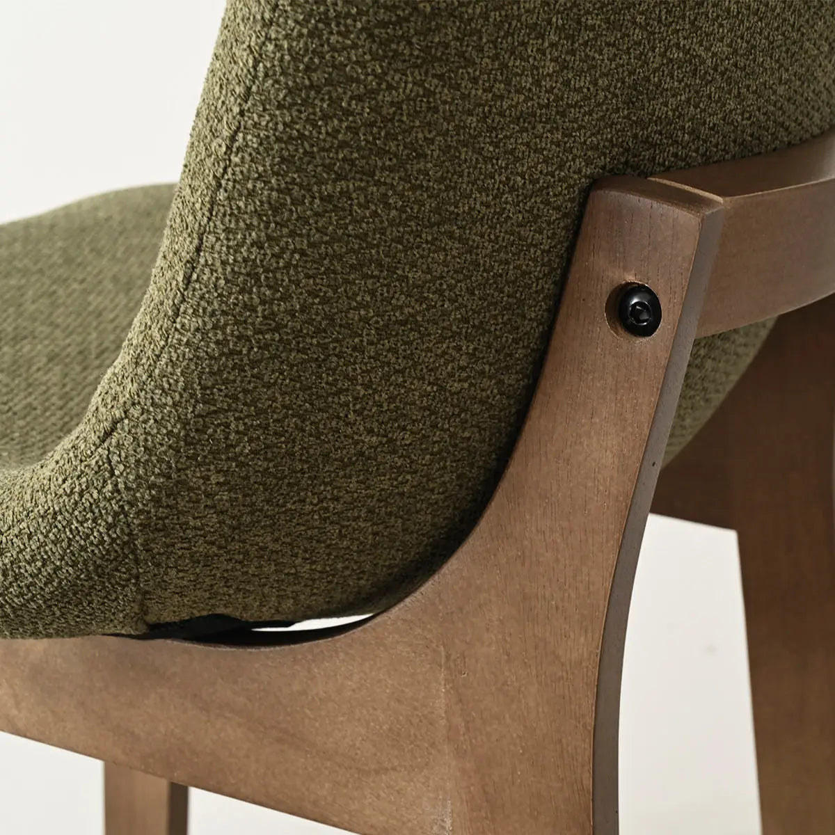 Close-up of green upholstered counter stool with wooden frame.