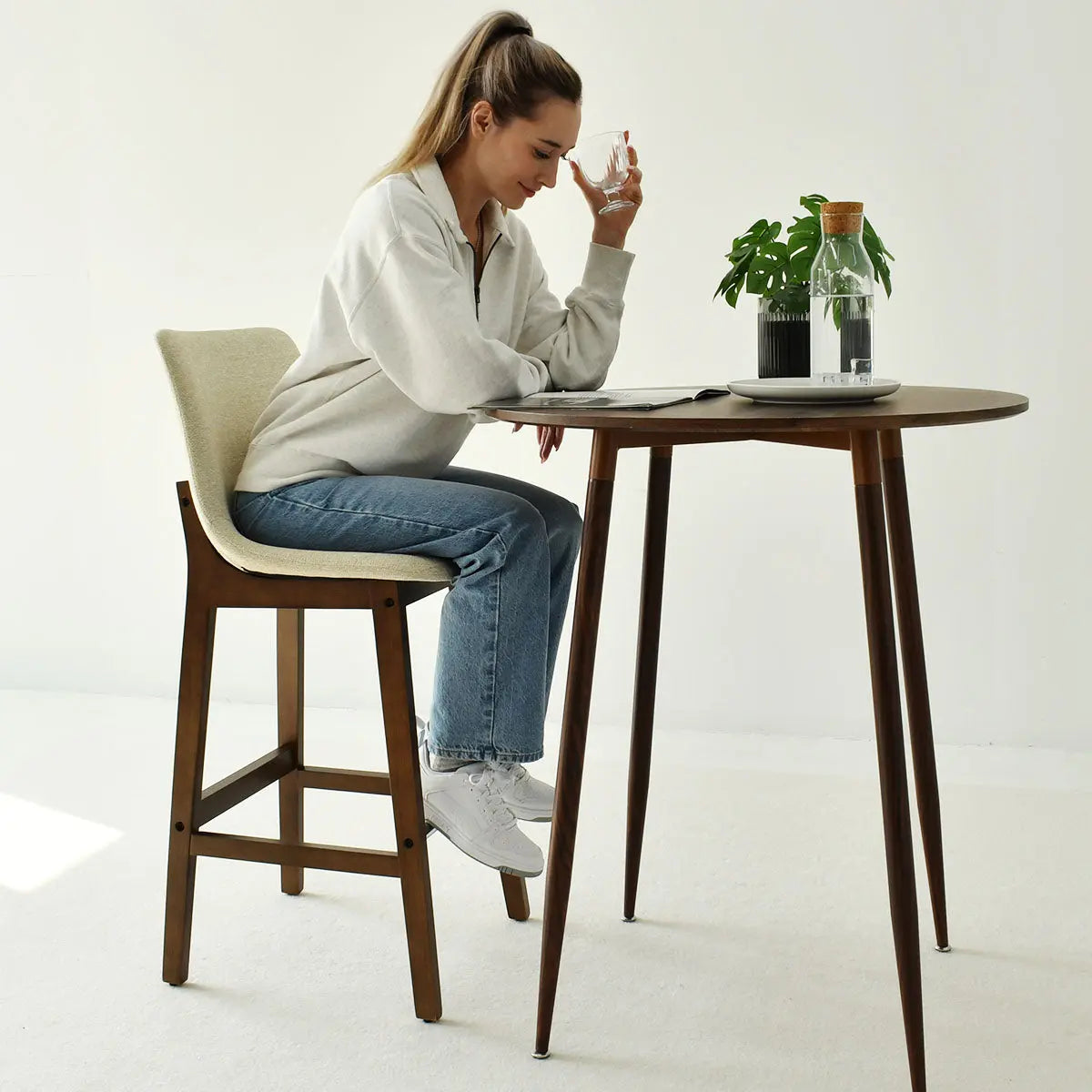 Modern South Upholstered Counter Stool with wood table, neutral room setting, white flooring.