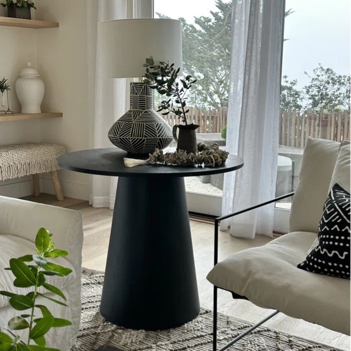 Dwen Modern Round Pedestal Dining Table in cozy living room, neutral sofa, light wood flooring.