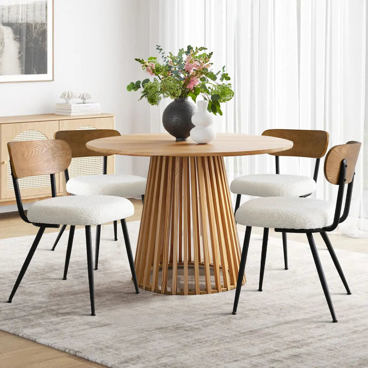 Skagen dining room with beige boucle chairs, ash back, round wooden table, light wood flooring.