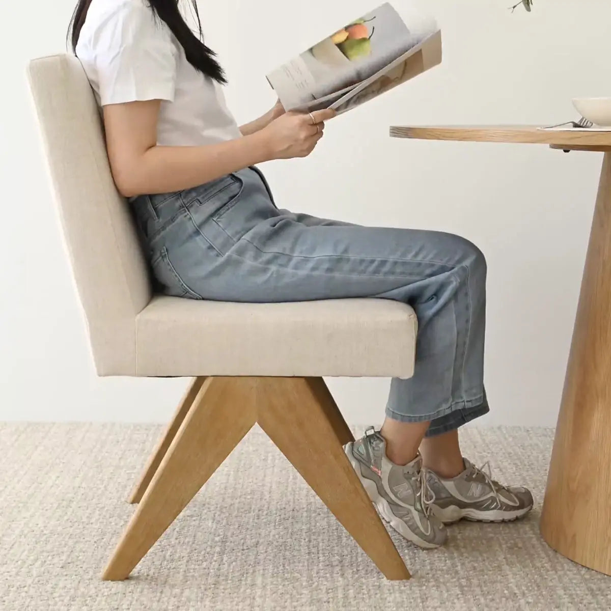 Morgan Mid-Century Boucle Dining Chair, light wood legs, beige upholstery, in modern dining room.