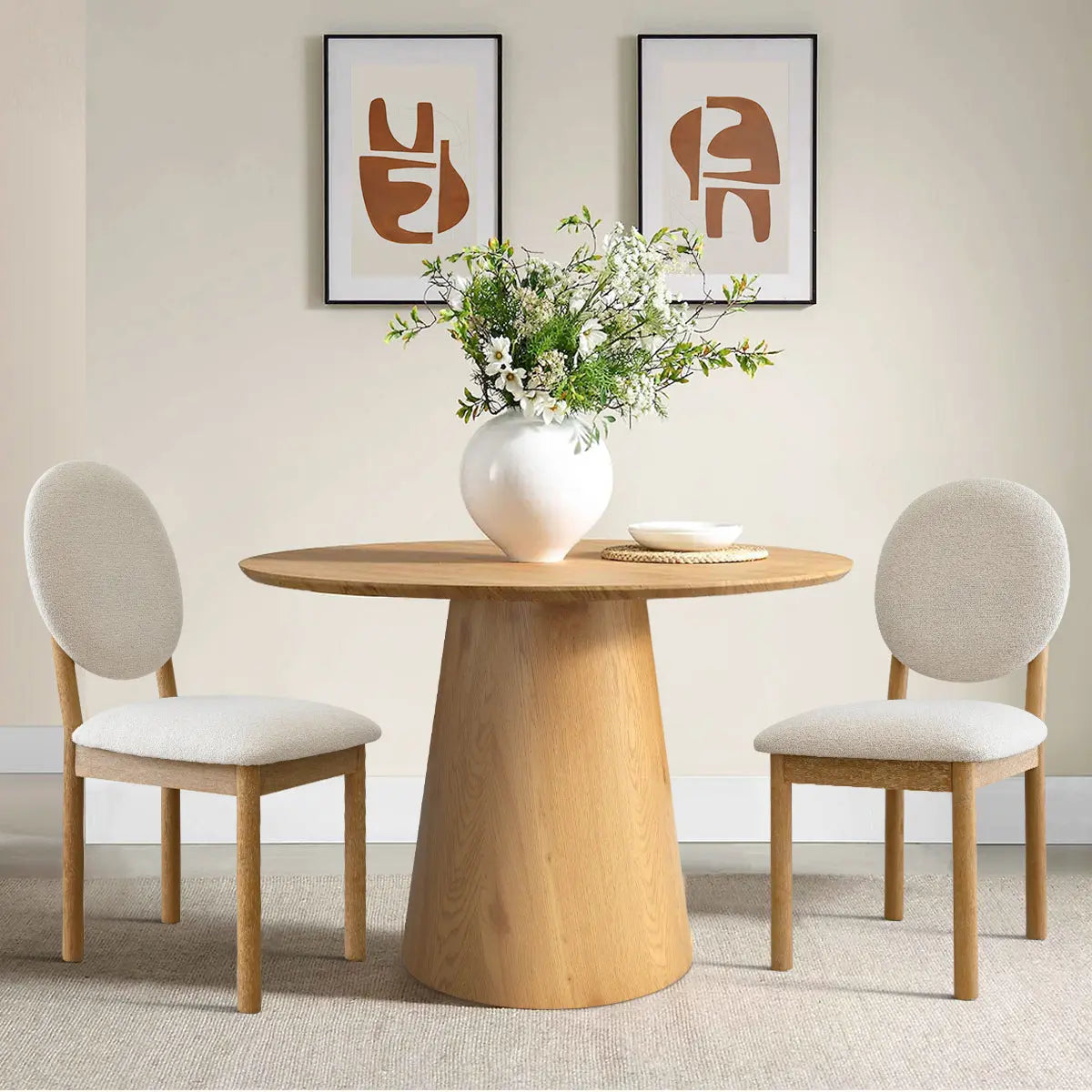 Maye Boucle Beige Dining Chair in neutral room with wooden table, beige walls, and abstract art.