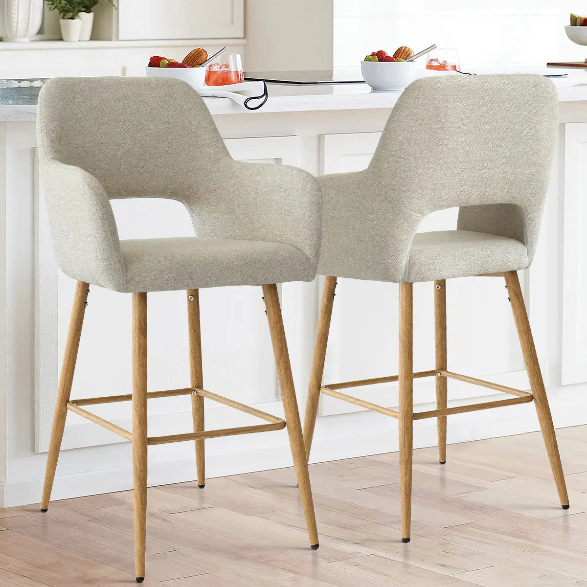 Atlanta Modern Upholstered Counter Stool with Arms, light wood legs, white kitchen, hardwood flooring.