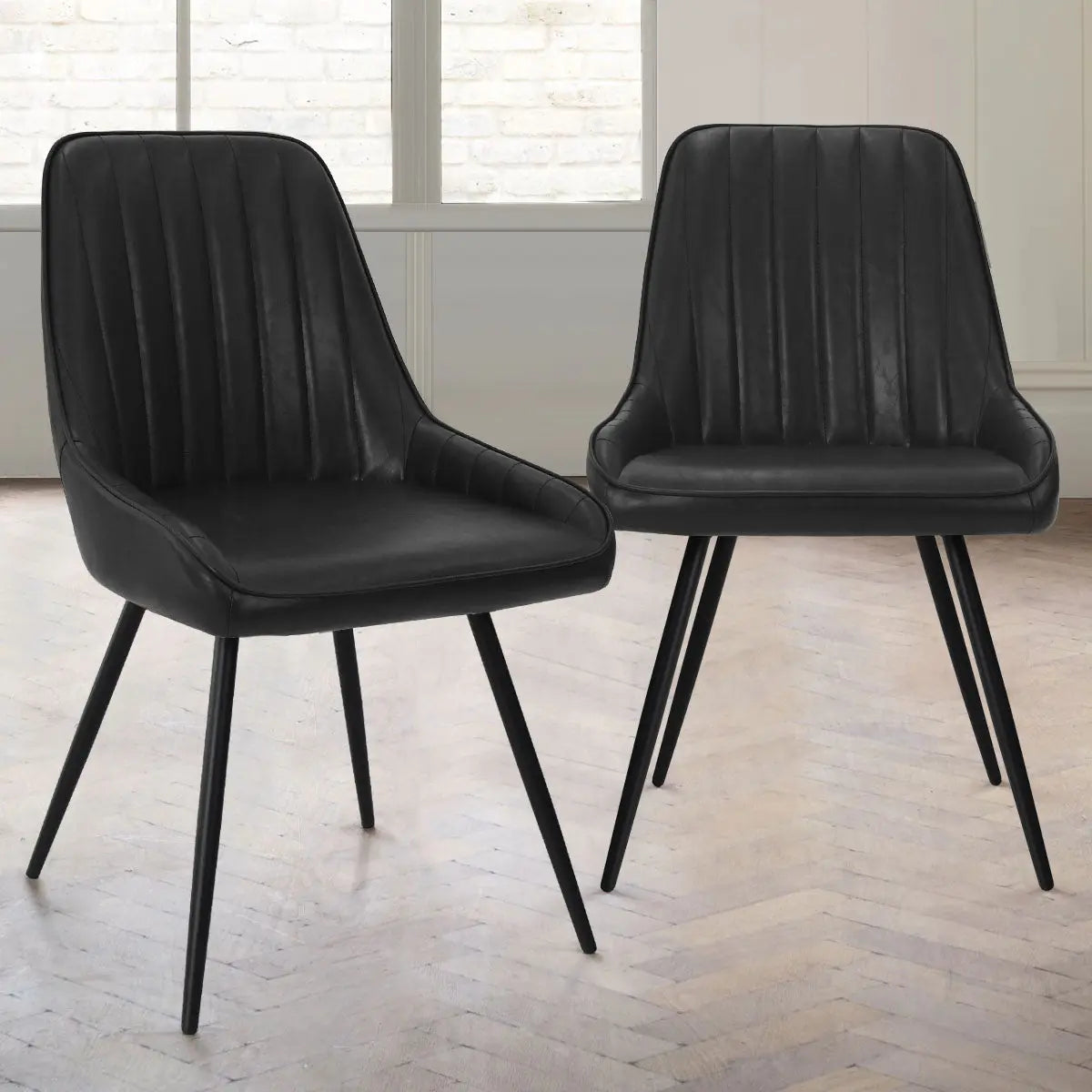 Two black Boston Leather Upholstered Dining Chairs in a well-lit dining room with wood flooring.