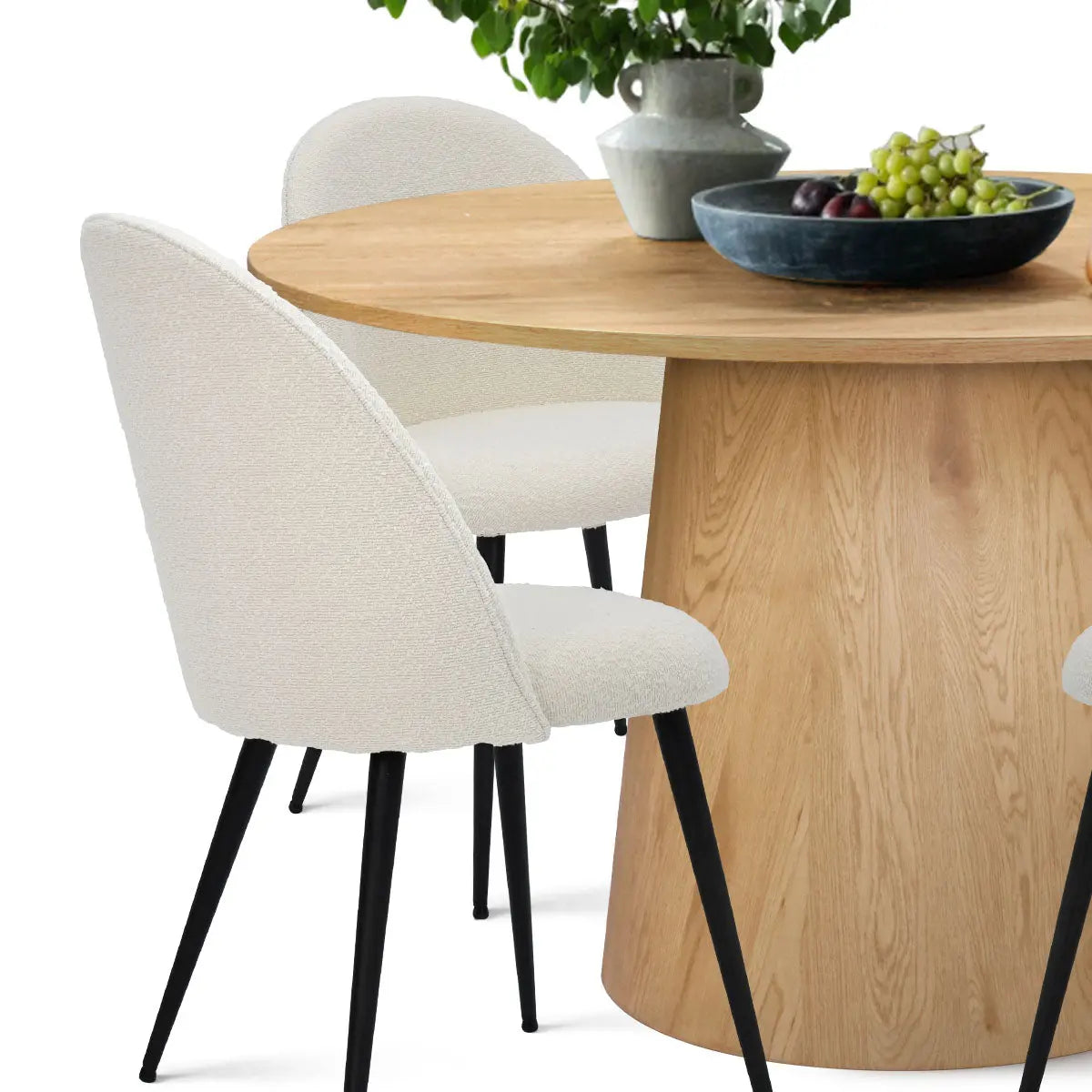 Dwen & Rhon dining table set with white chairs, wood pedestal, and modern decor accents.