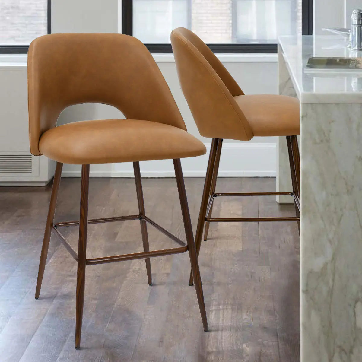 Edwin 26" faux leather counter stools set in modern kitchen with wood floors and marble island.