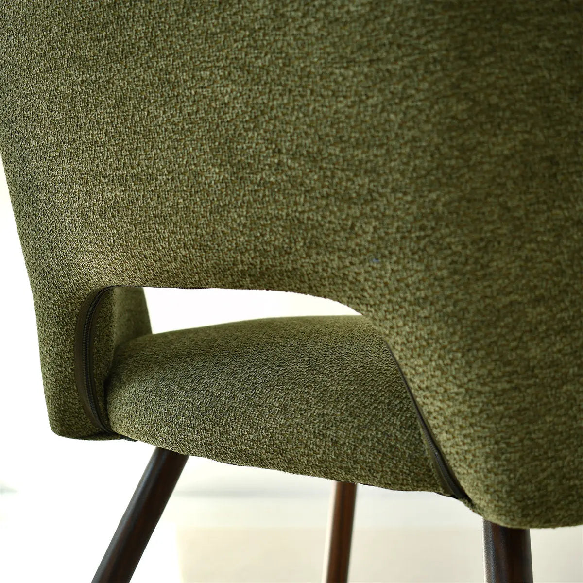 Edwin Modern Boucle Dining Chair, green upholstery, wooden legs, shown close-up in detail.